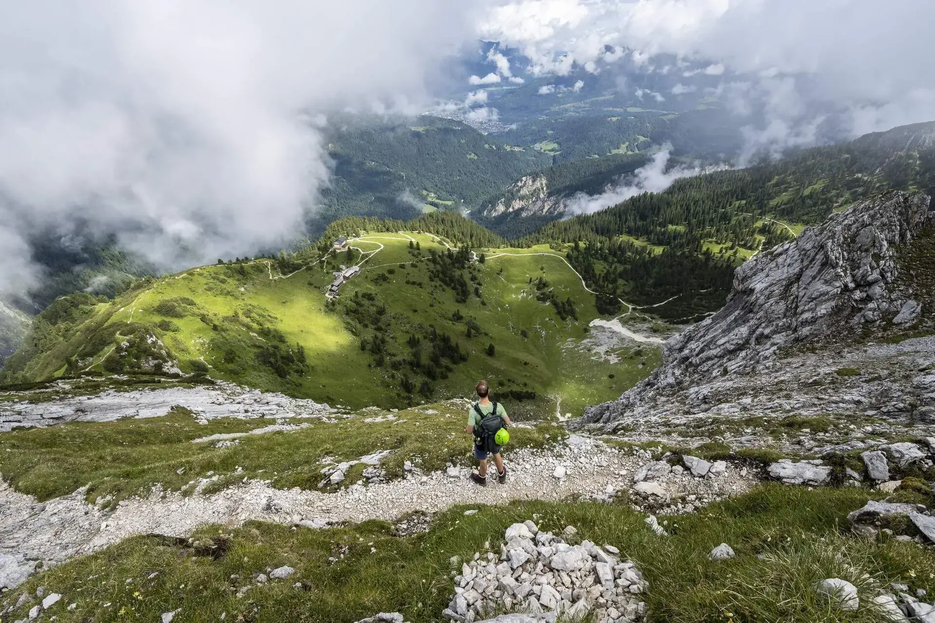 Hiker on hiking trail to Meilerhuette high up in the skies with a beautiful view of the mountains 