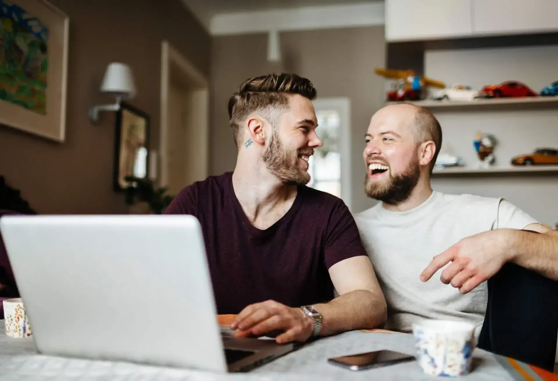LGBTQ couple looking at computer laughing
