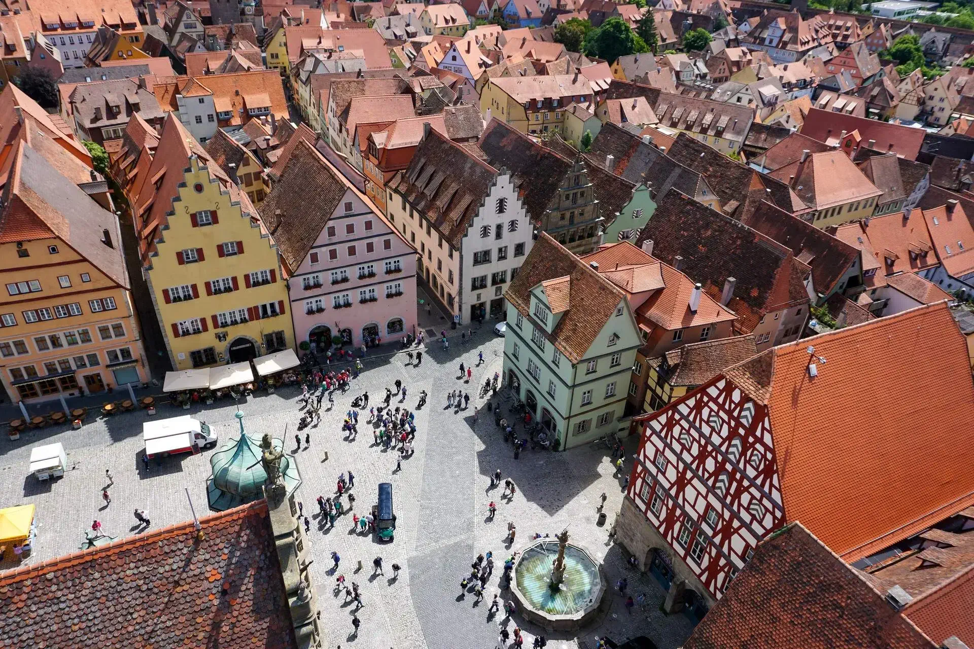 There is a plaza with fountains in the middle of the village where people gather to relax and eat outside at cafes. 