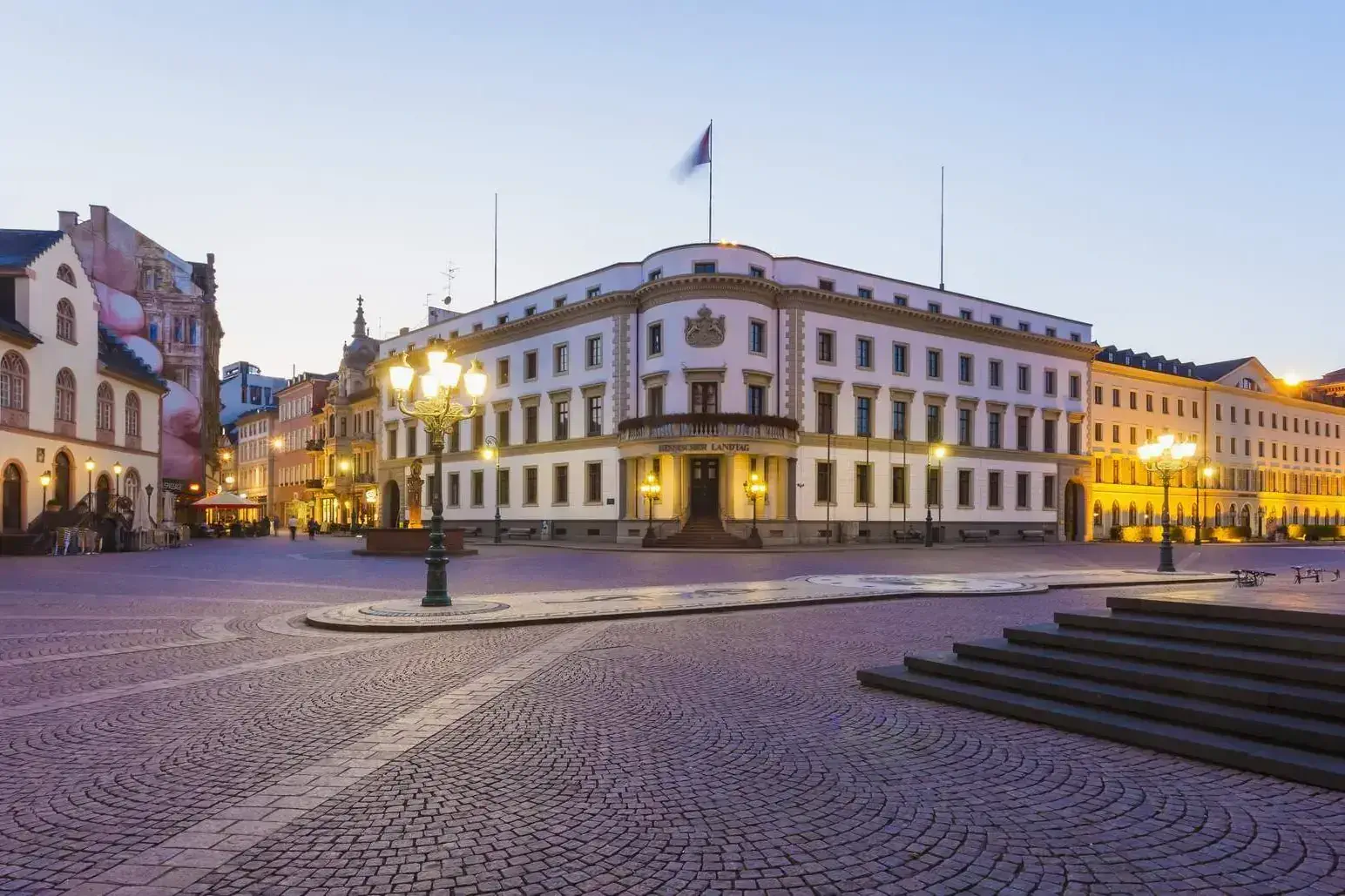 The Hessischer Landtag building at the corner of the town plaza, which was illuminated by street lamps.