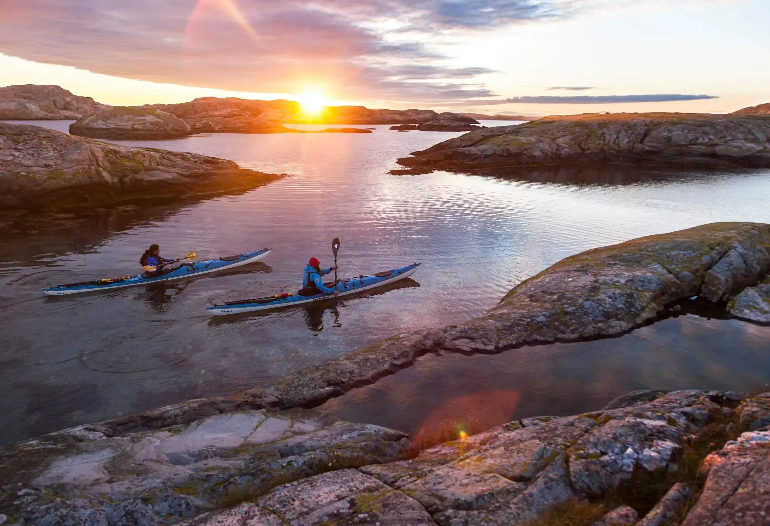 two people in kayaks in the swedish archipelago