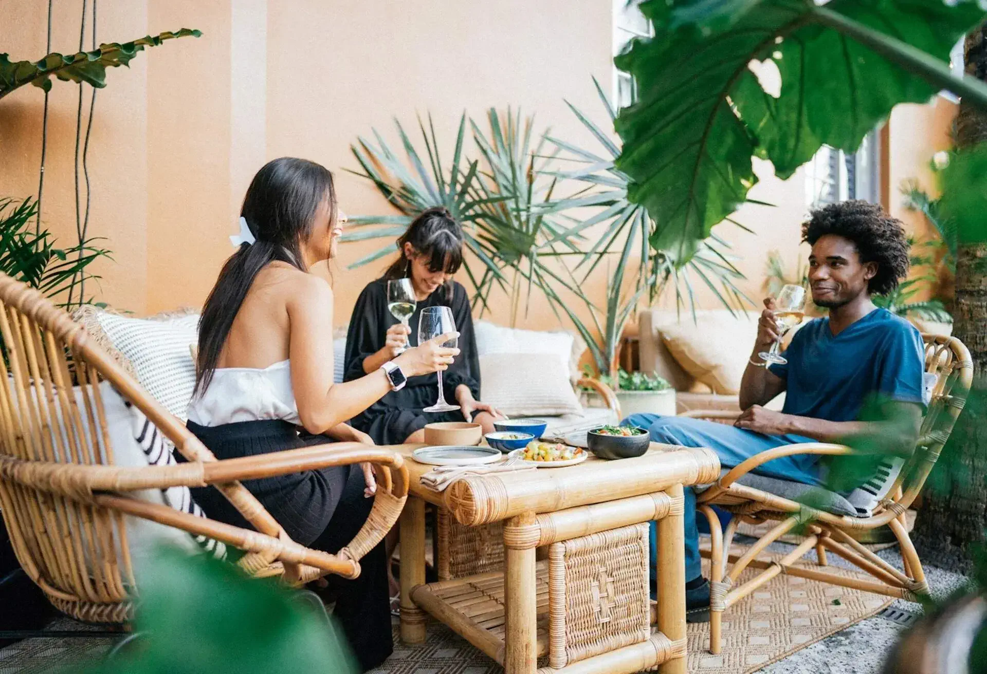 Friends sitting in a hotel patio, chatting and having drinks,