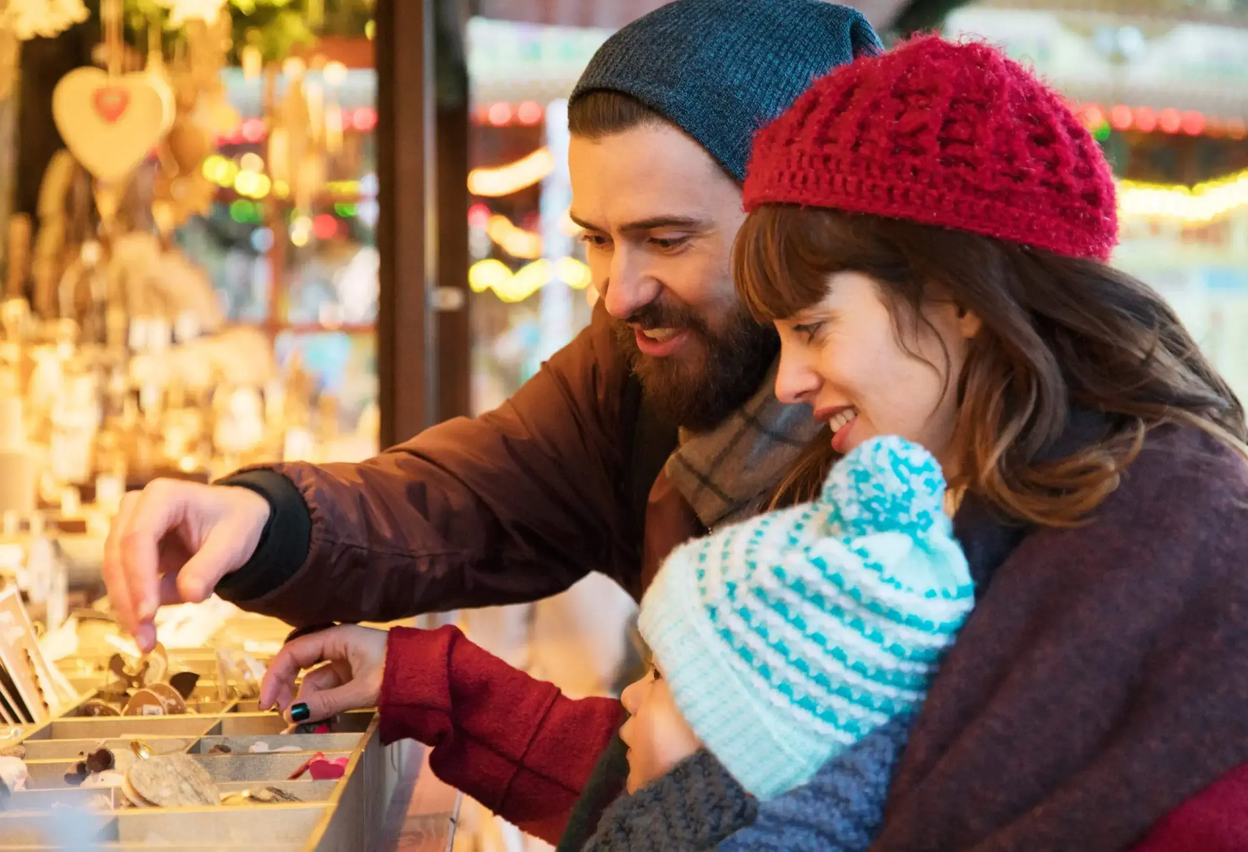Happy family with  small child shopping for trinkets at Christmas Market