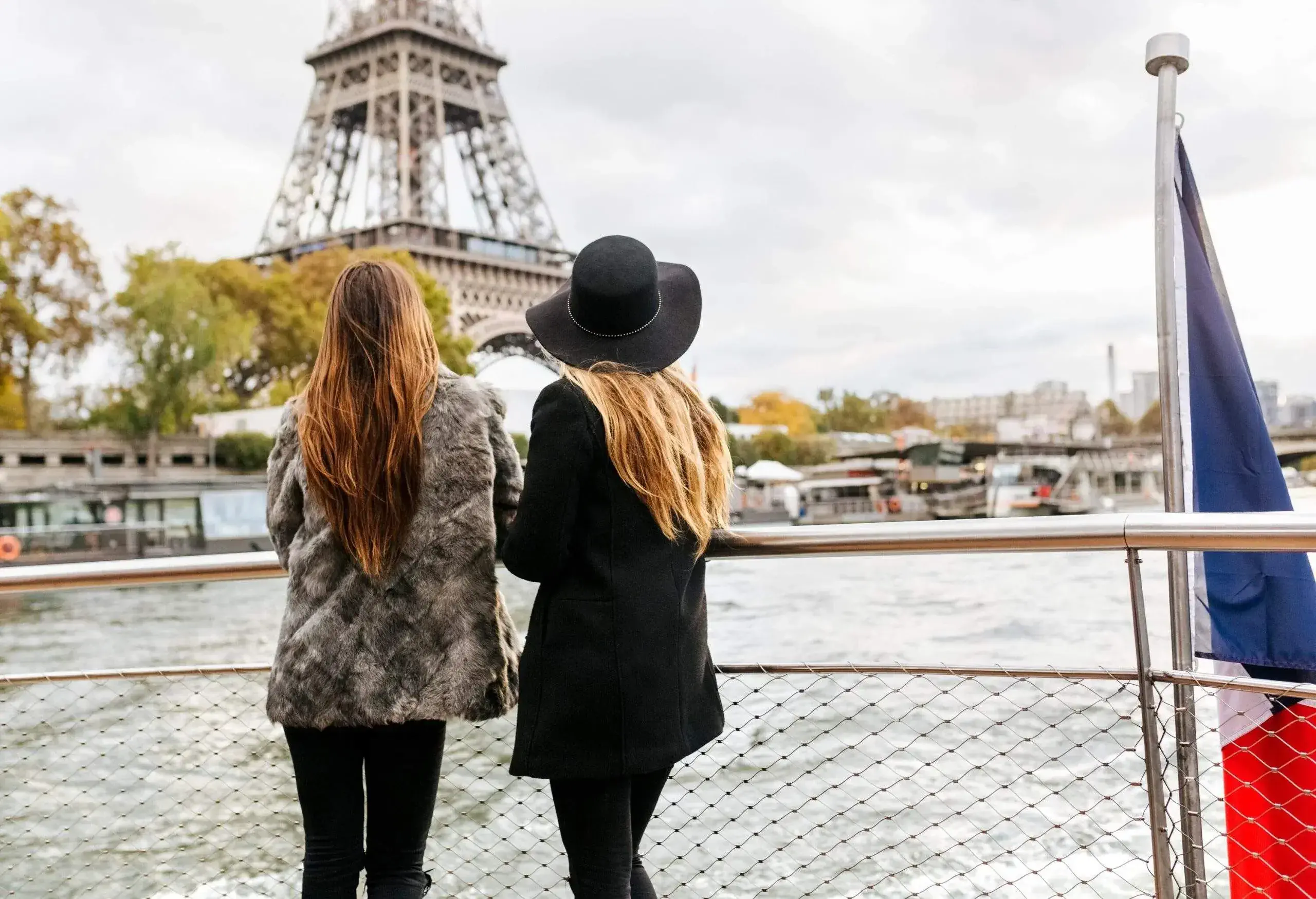 Two women on a boat on the Seine, looking at the Eiffel Tower