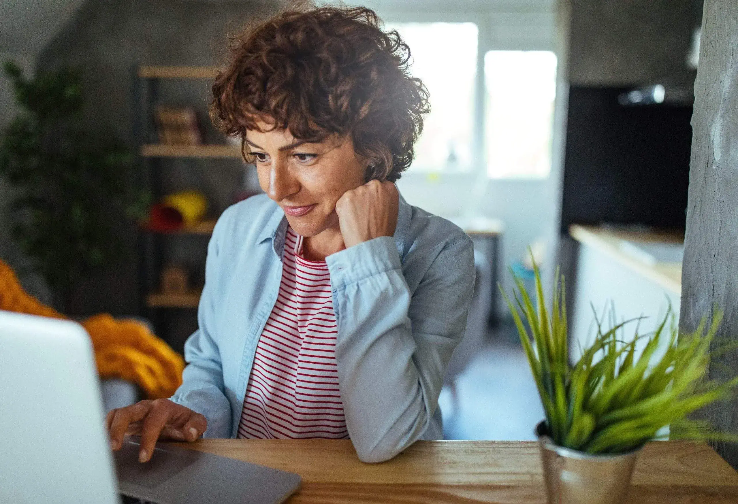 A woman smiling while looking at her computer