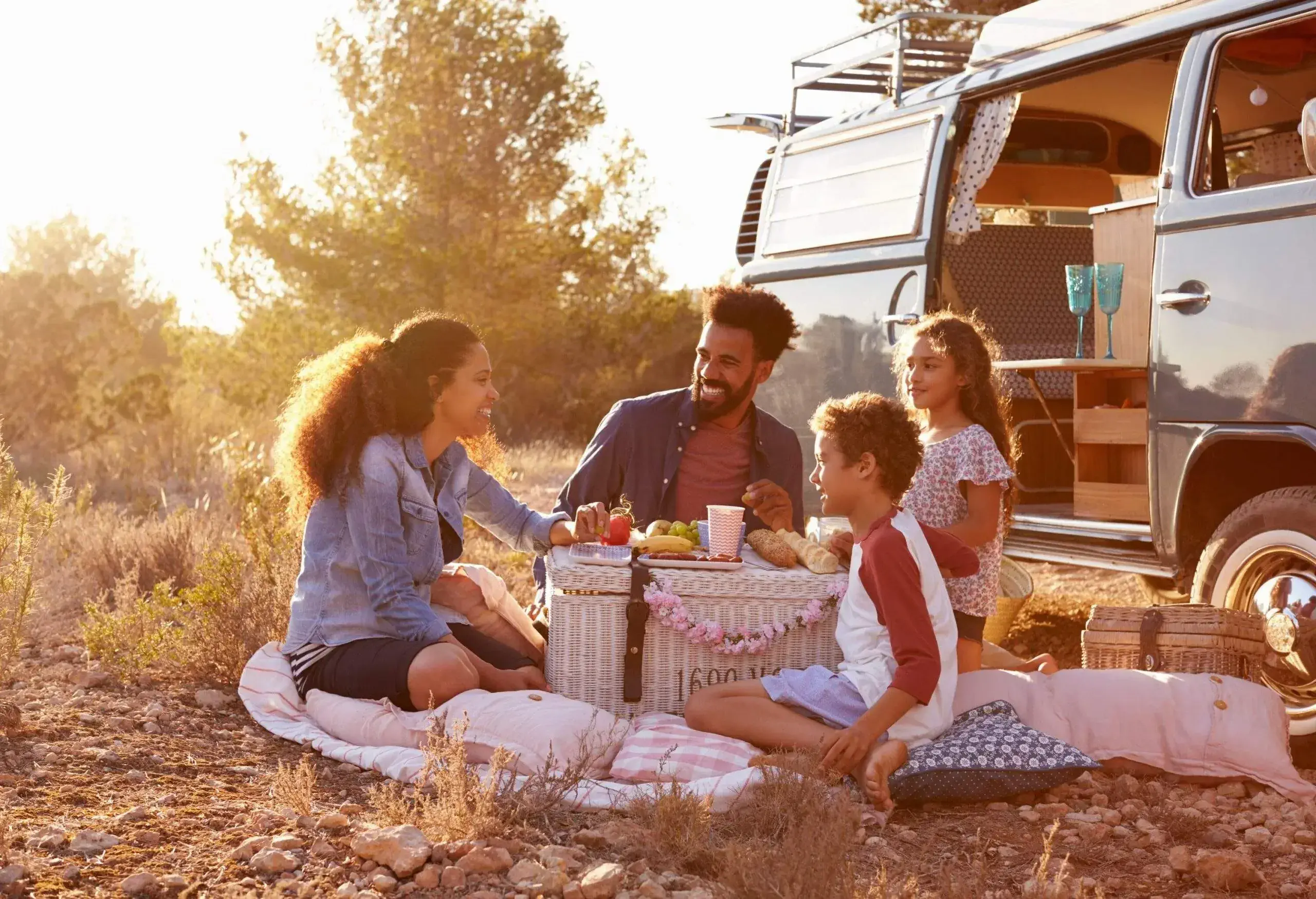 A happy family having a pic-nic next to their camper van