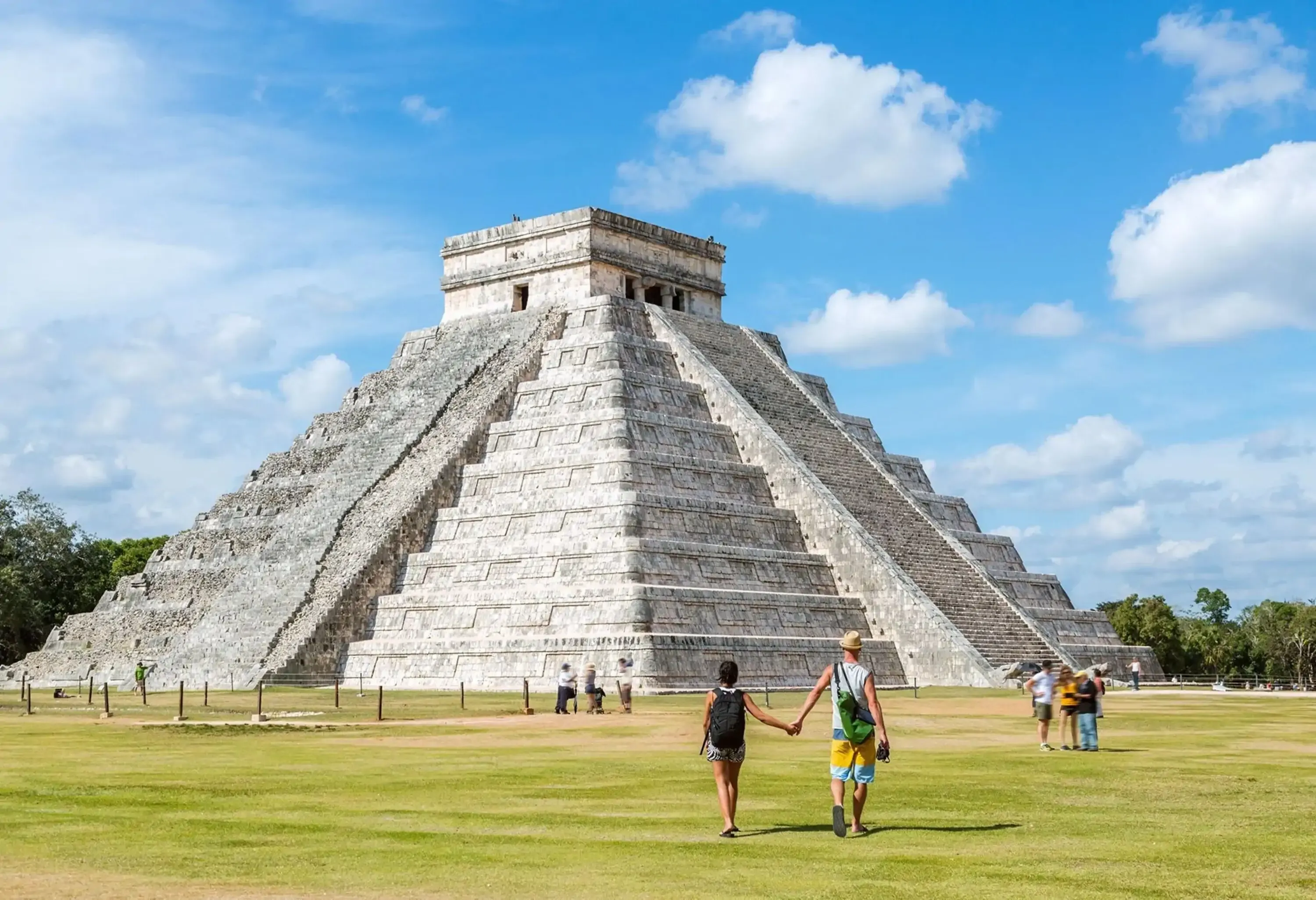 Tourist couple in front of El Castillo temple, Chichen Itza, Yucatan, Mexico