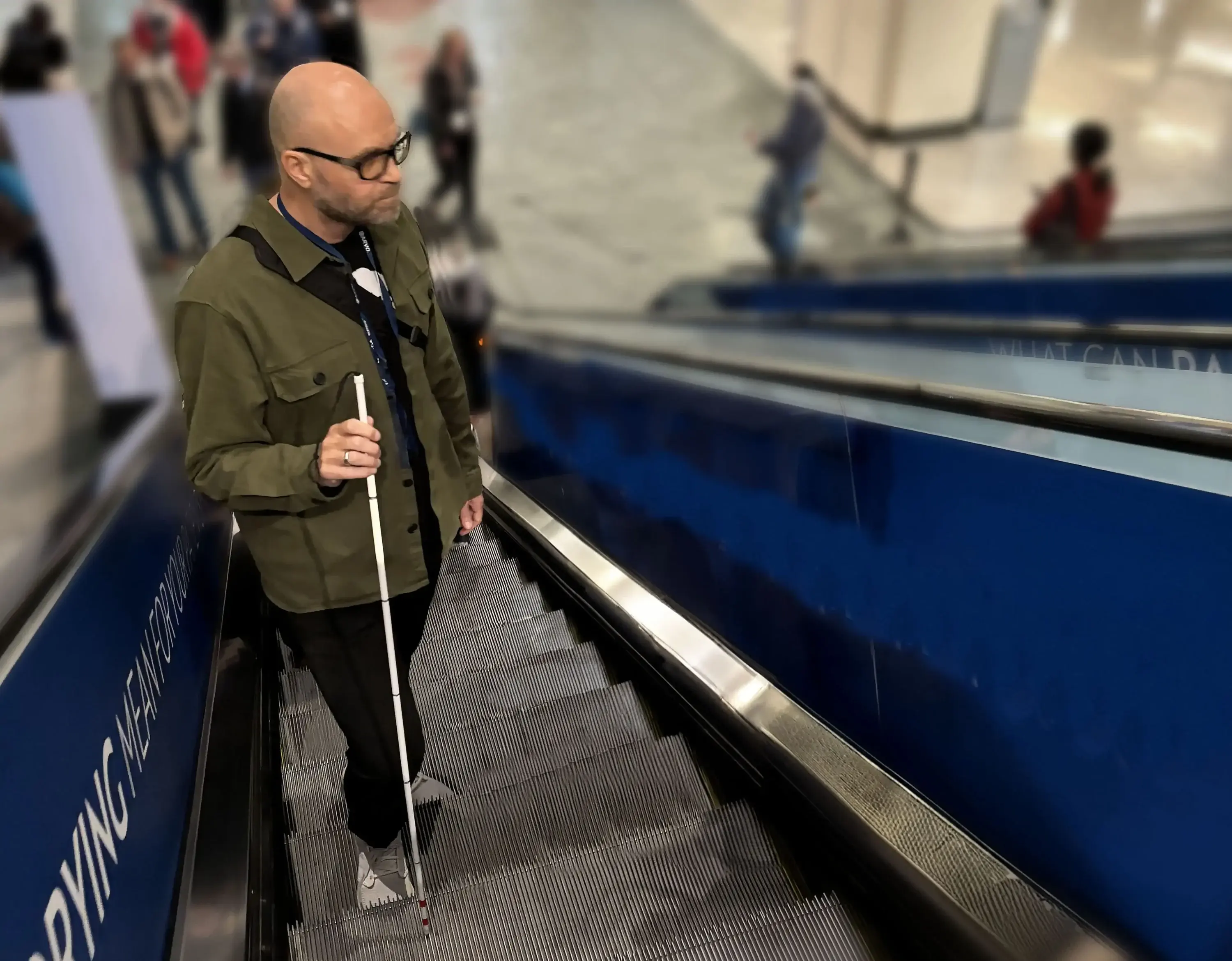 Morten Bone with his cane on an escalator at the airport