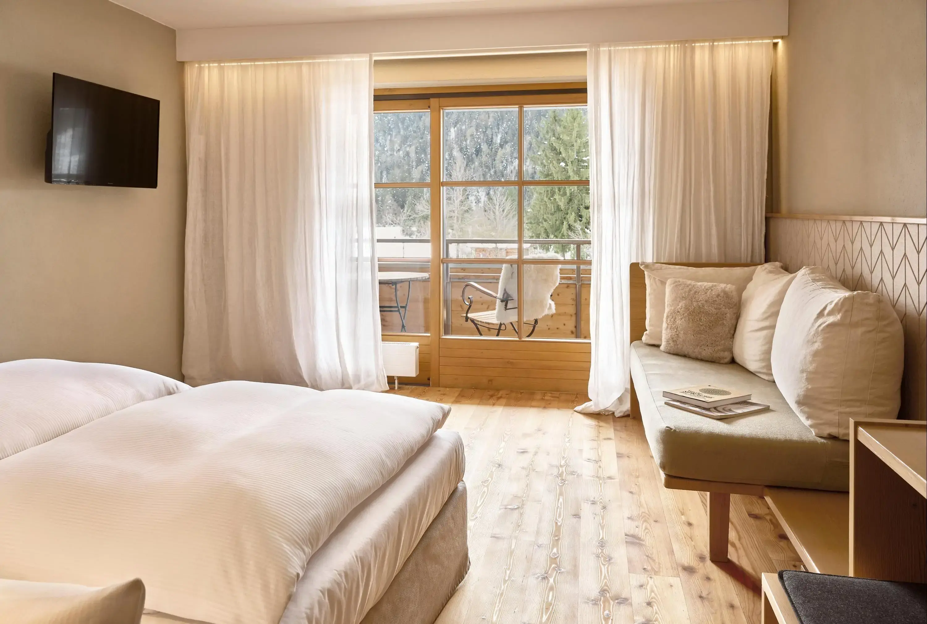 A cozy bedroom featuring a bed, a window allowing natural light, and a comfortable couch for relaxation.