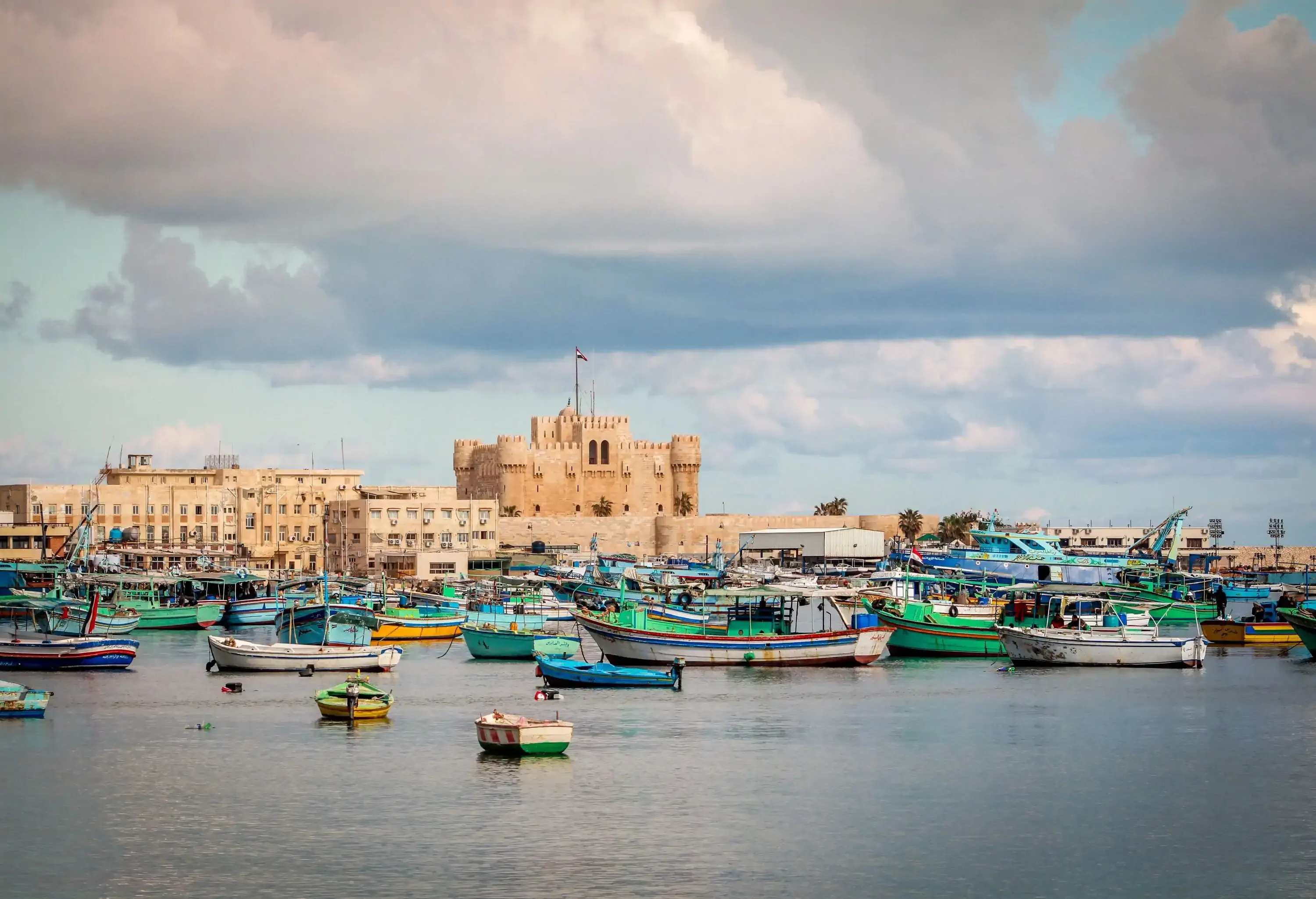 Ancient fortified city by the sea with colourful boats in the foreground