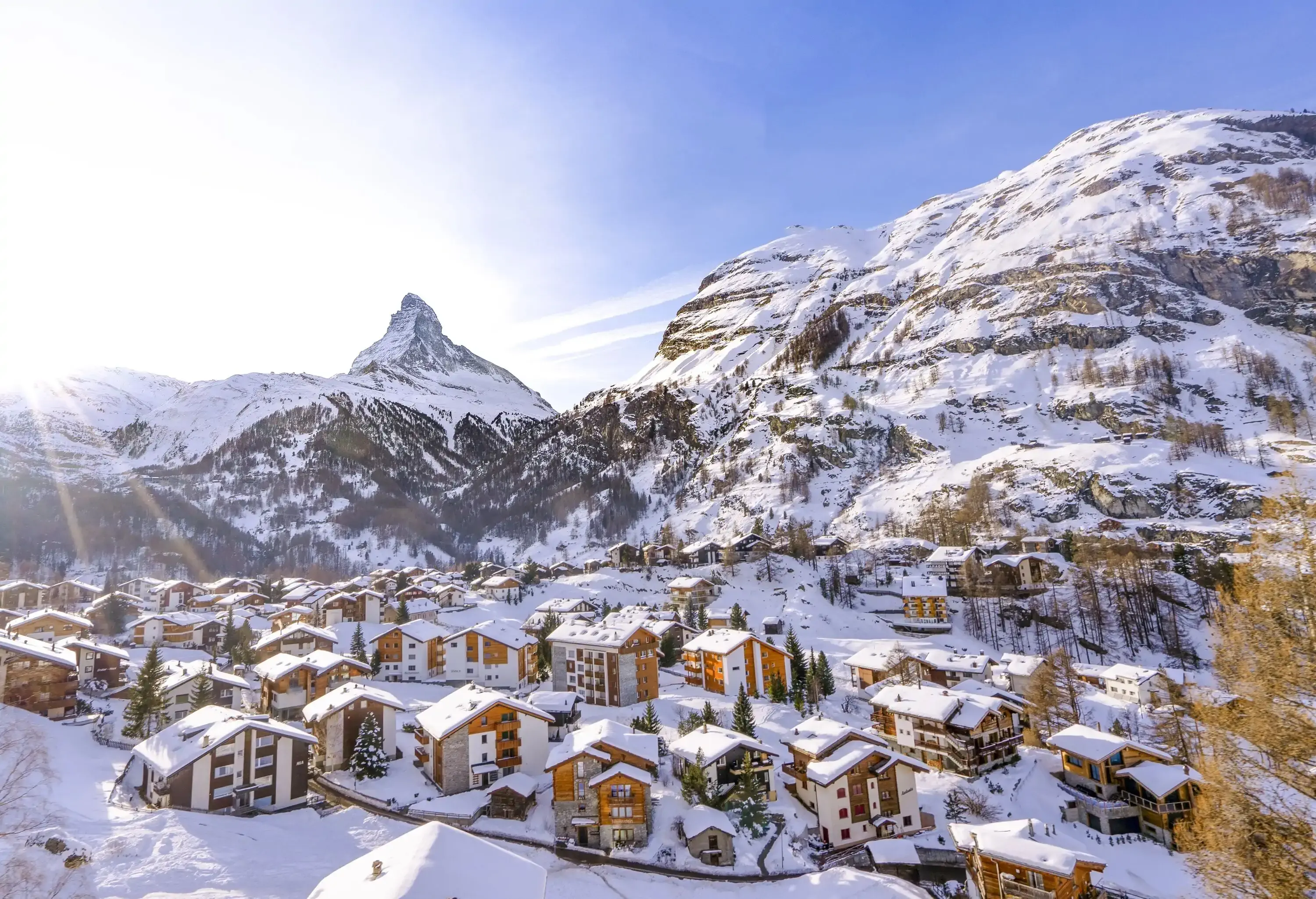 Village in a valley covered in snow with mountain peaks in the background