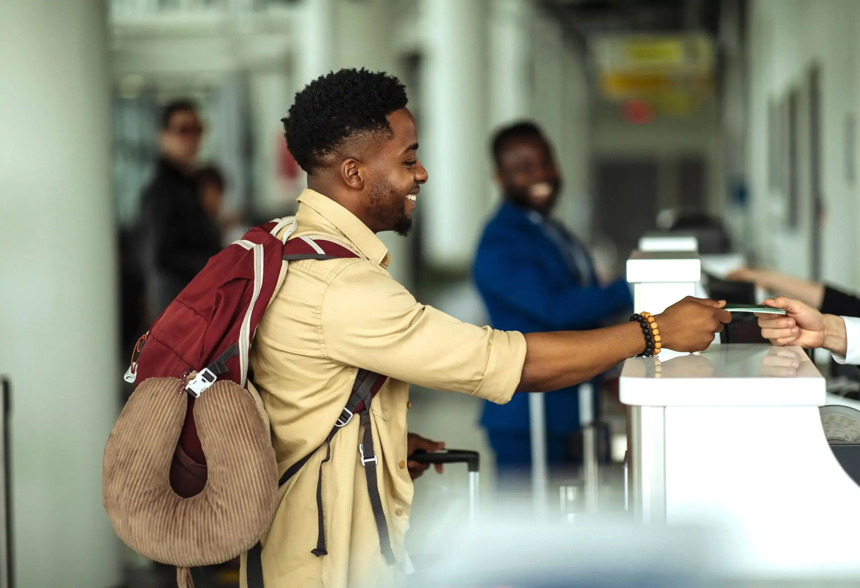 Side view of a young man standing in front of the airport counter