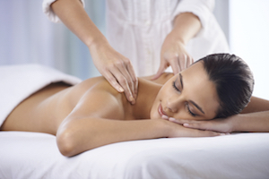 A young woman receiving a massage from a massage professional