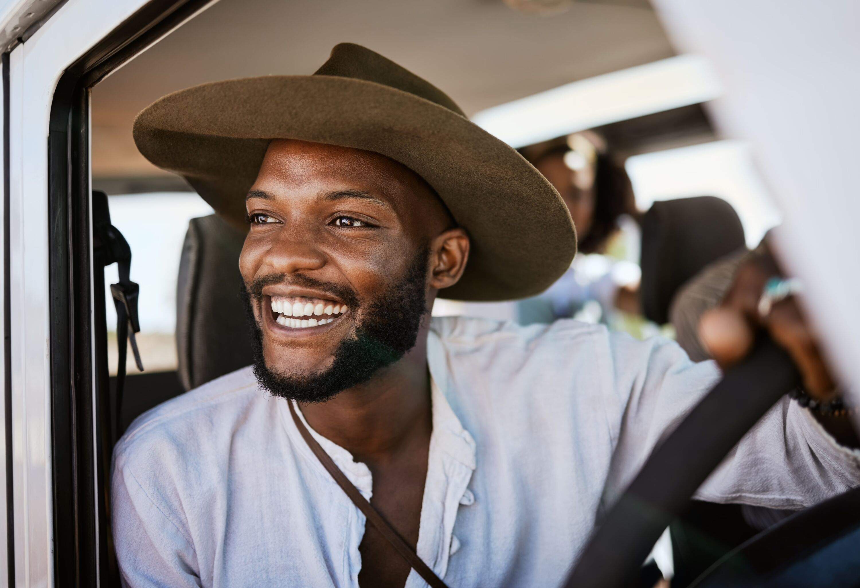 Happy, taxi and driver with man driving and enjoying career, safari tour guide in vehicle. Adventure, travel and smile african american looking excited while touring with passenger, carefree
