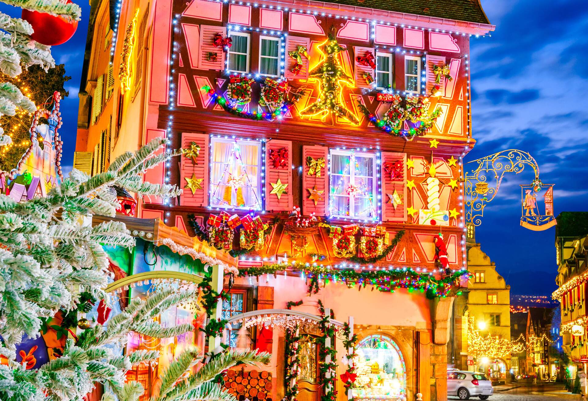 A traditional half-timbered house decorated with various colourful Christmas ornamentals and Christmas lights