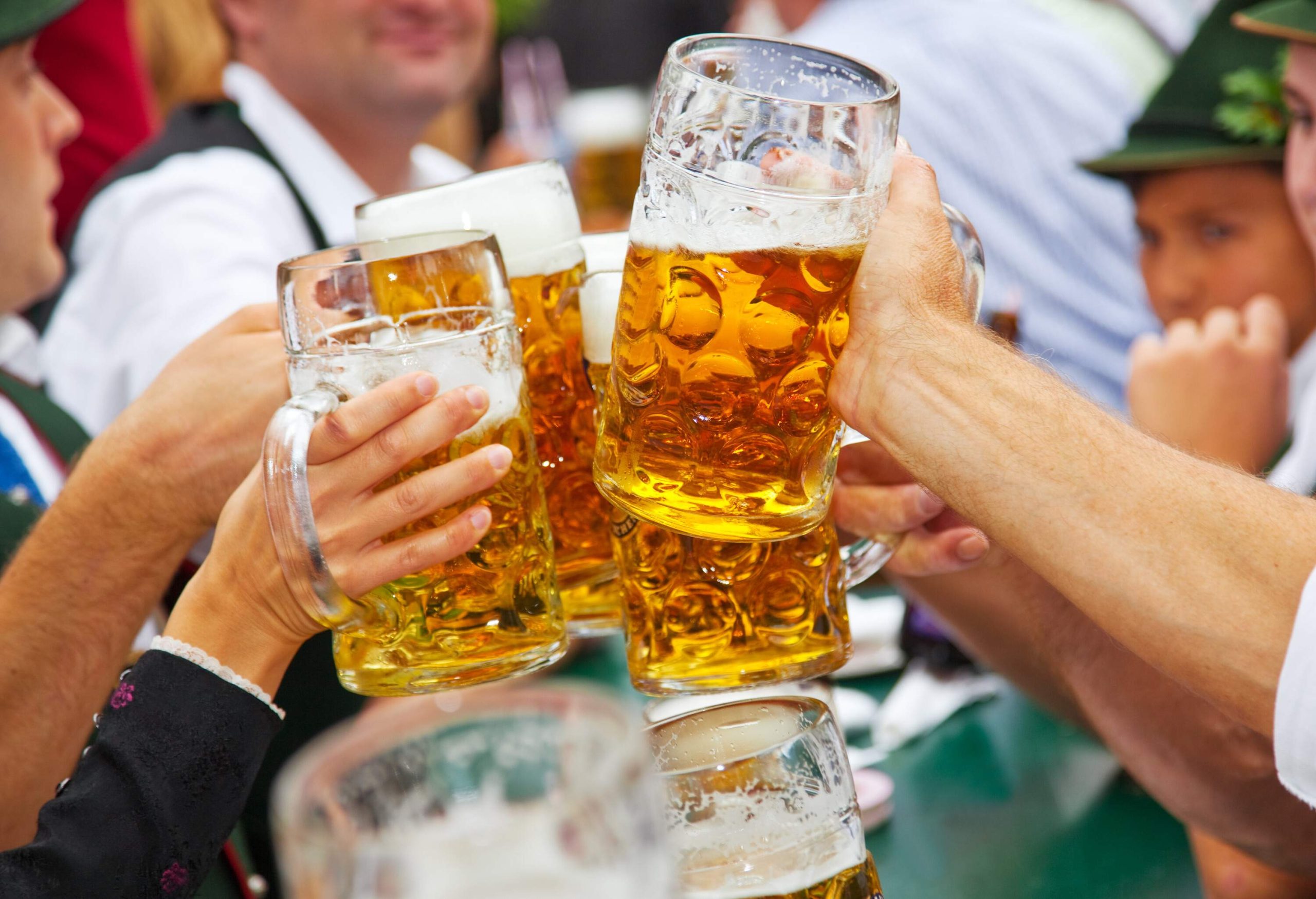 A group of people clinking their beer mugs together.