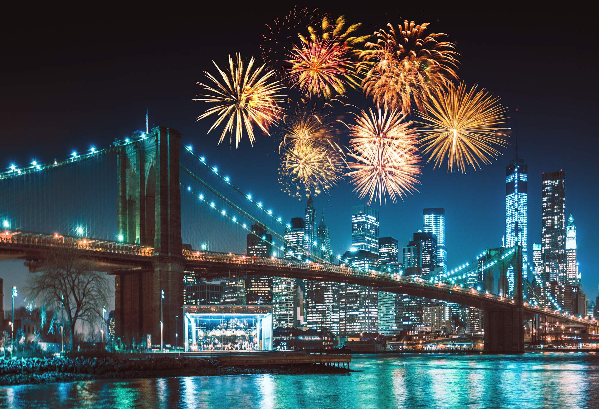 Fireworks and city lights illuminating the Manhattan Bridge skyline.