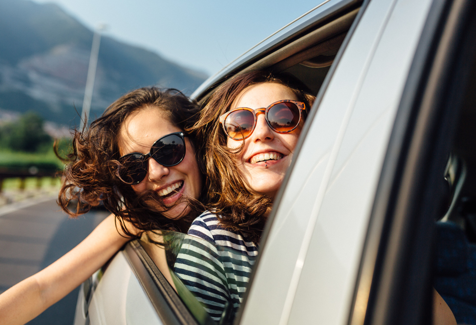 young women friends enjoying car trip.