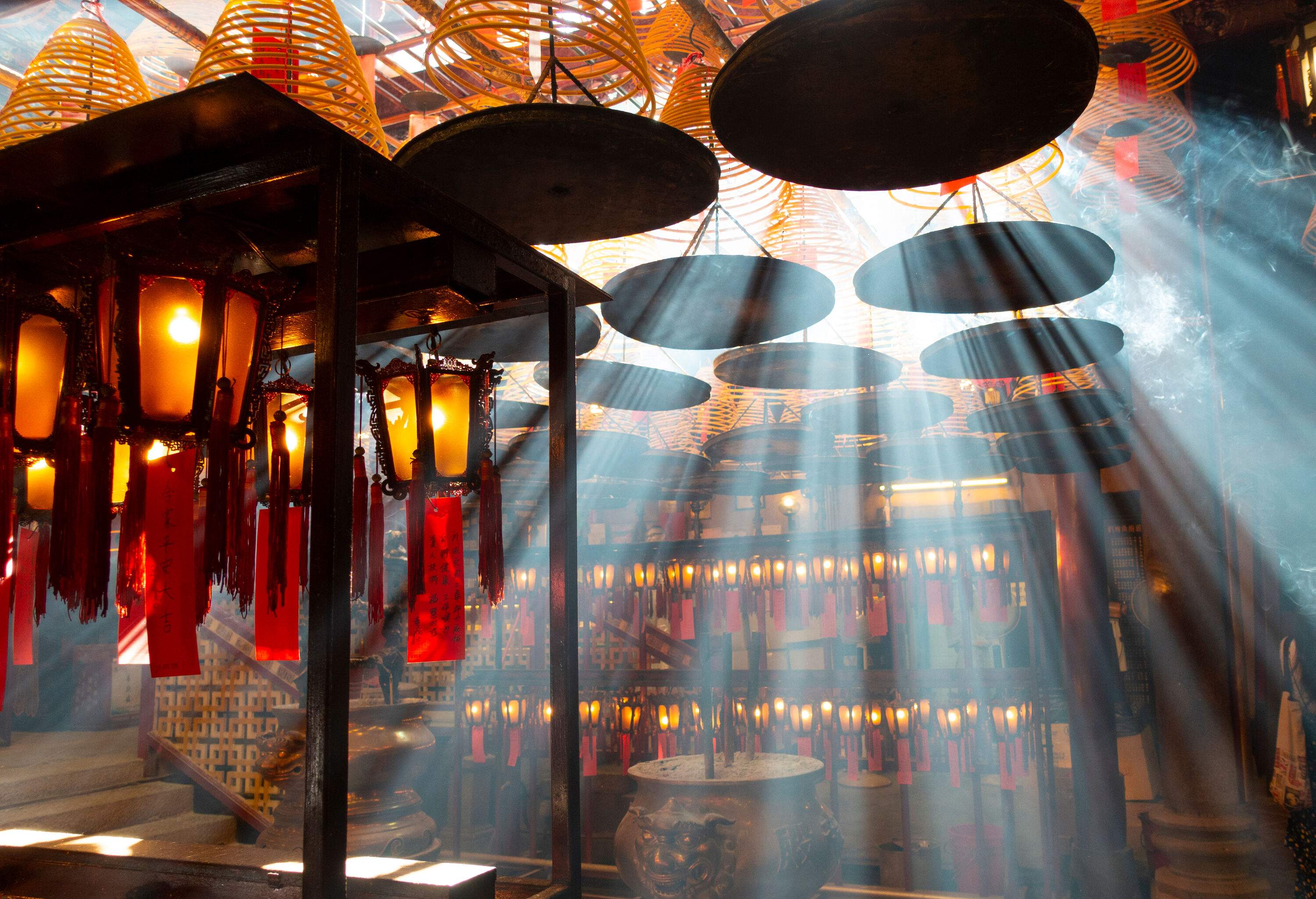 Radiant sun rays streaming into the room filled with lanterns hanging from the ceiling.
