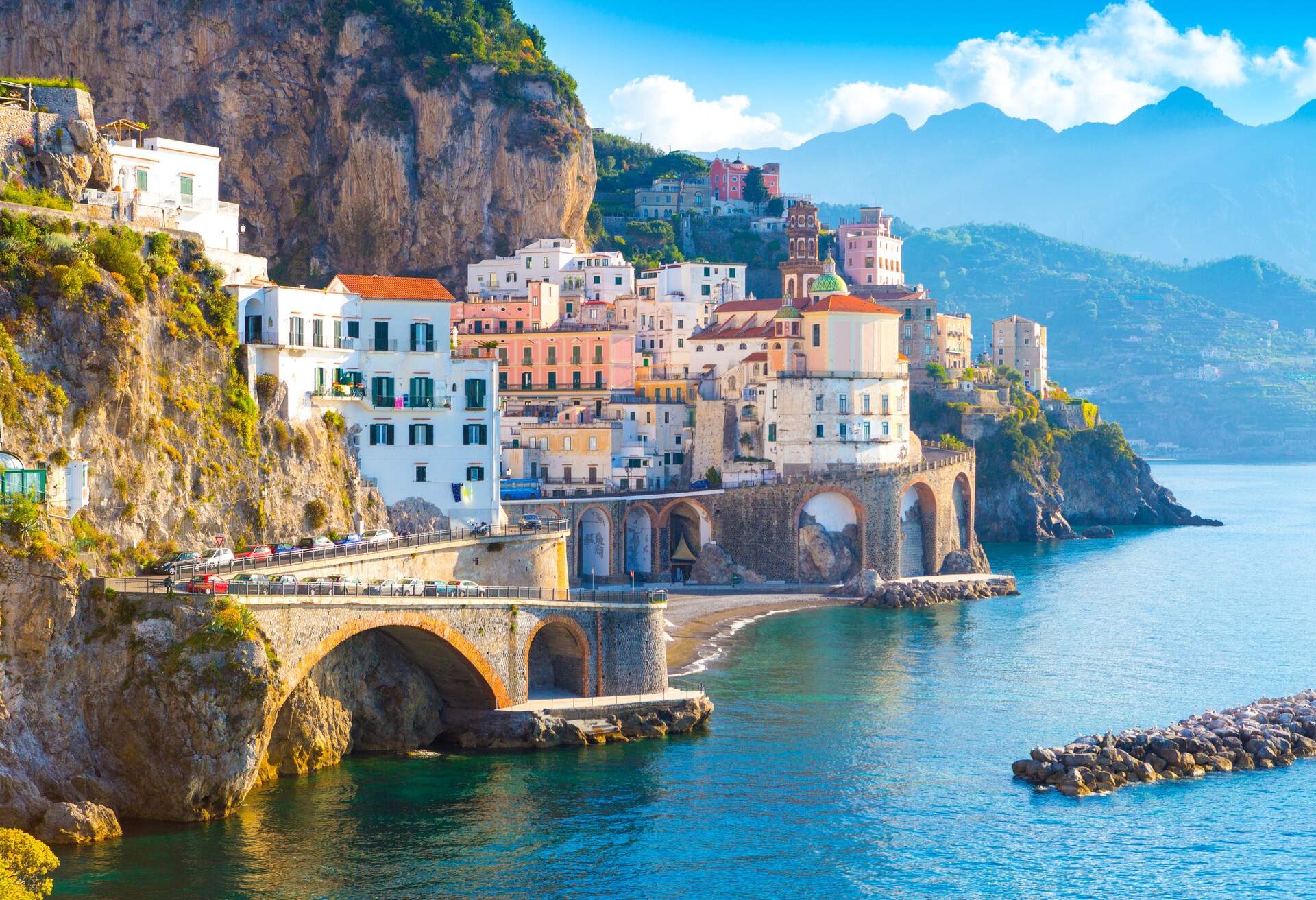 Compact, colourful buildings clustered on the steep mountainside above the sea.