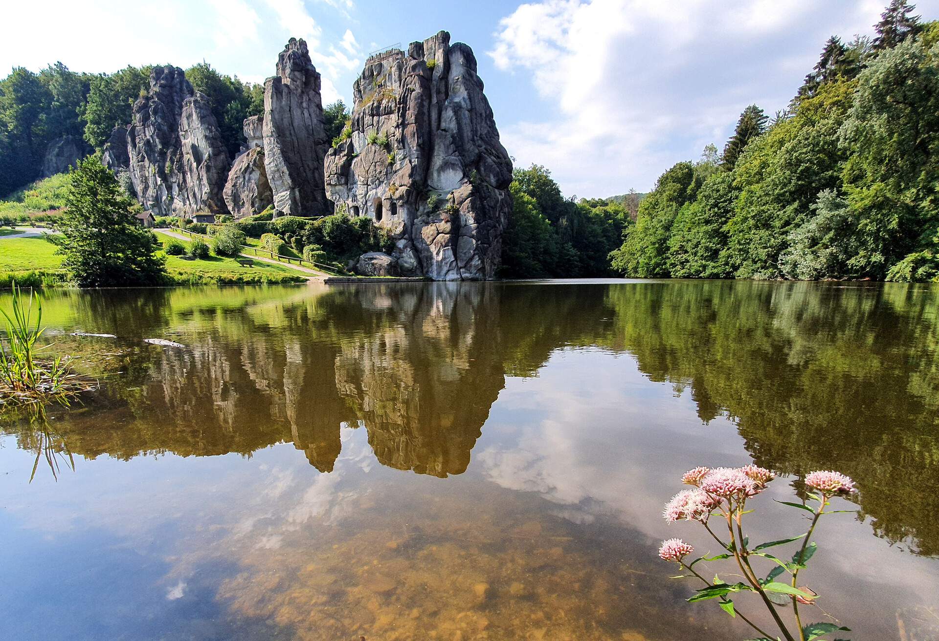 The Externsteine is a peculiar sandstone rock formation located in the Teutoburg Forest, in the German state of North Rhine-Westphalia. The formation consists of several tall, narrow columns of rock which rise abruptly from the surrounding wooded hills..The site draws about a million visitors a year, for a variety of reasons.