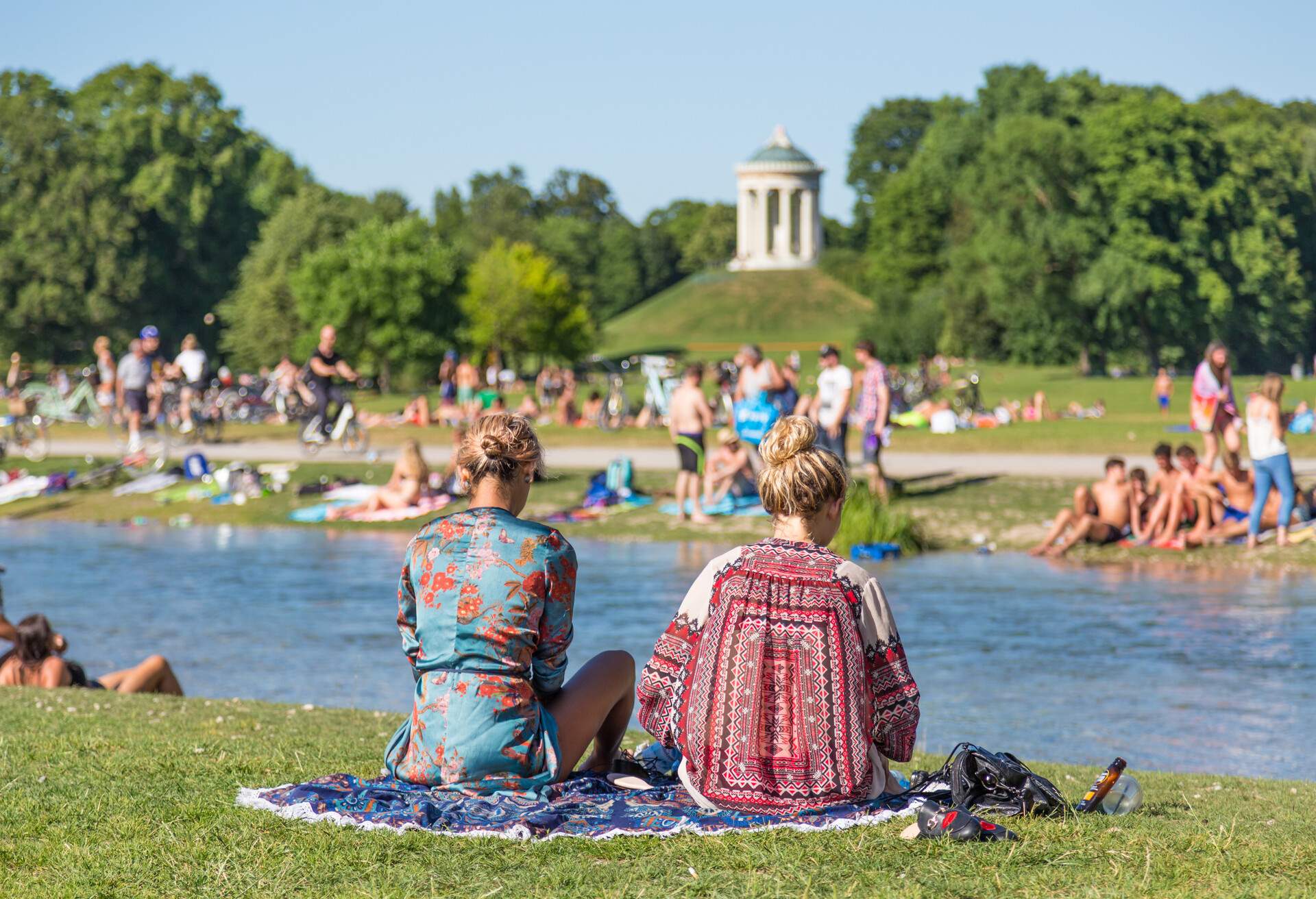 Locals and tourists enjoy the sunny weather swimming on the river and sunbathing on the lush banks.