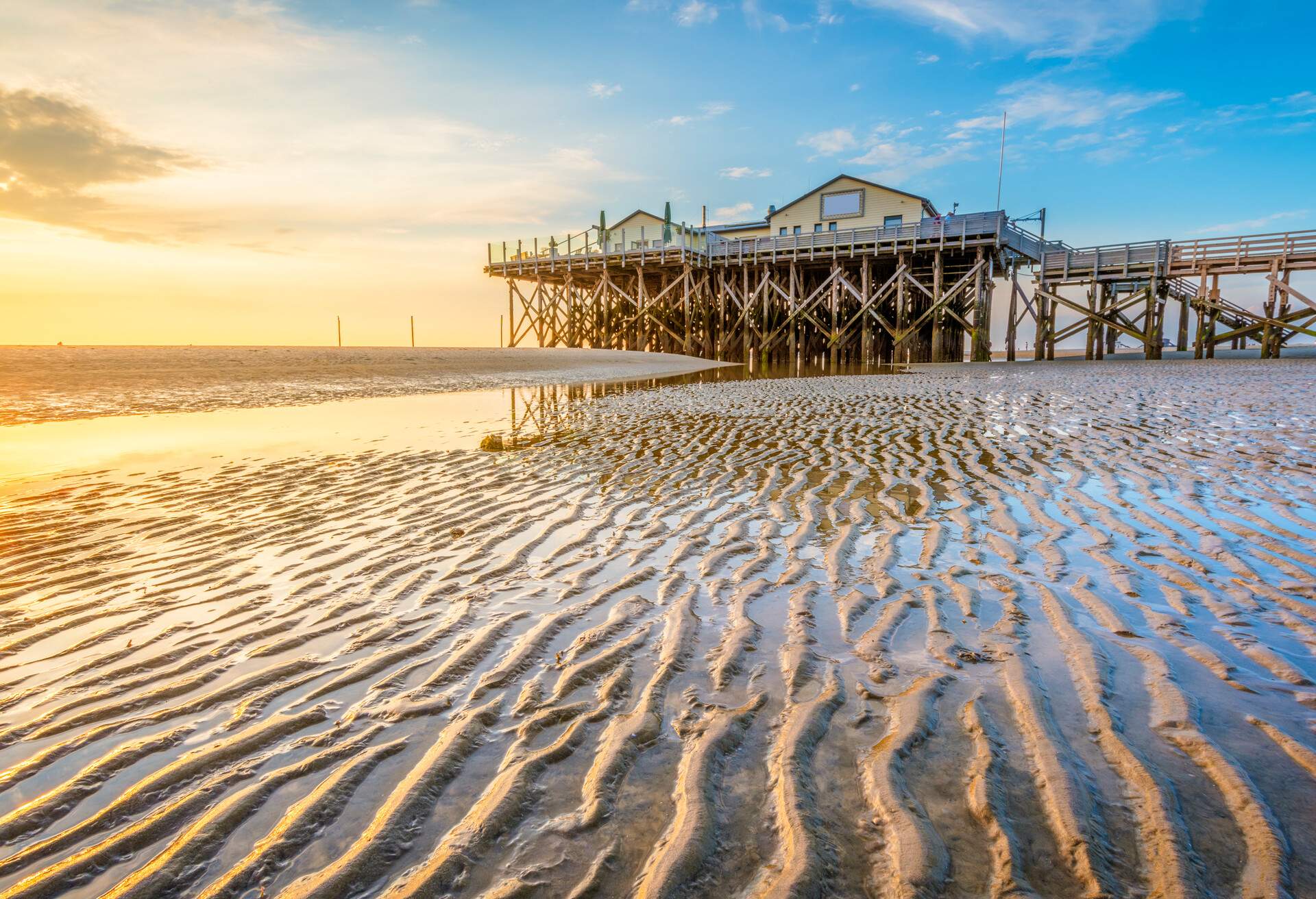 Sankt Peter-Ording, Eiderstedt, North Frisia, Schleswig-Holstein, Germany. Stilt house on the Wadden sea with low tide.