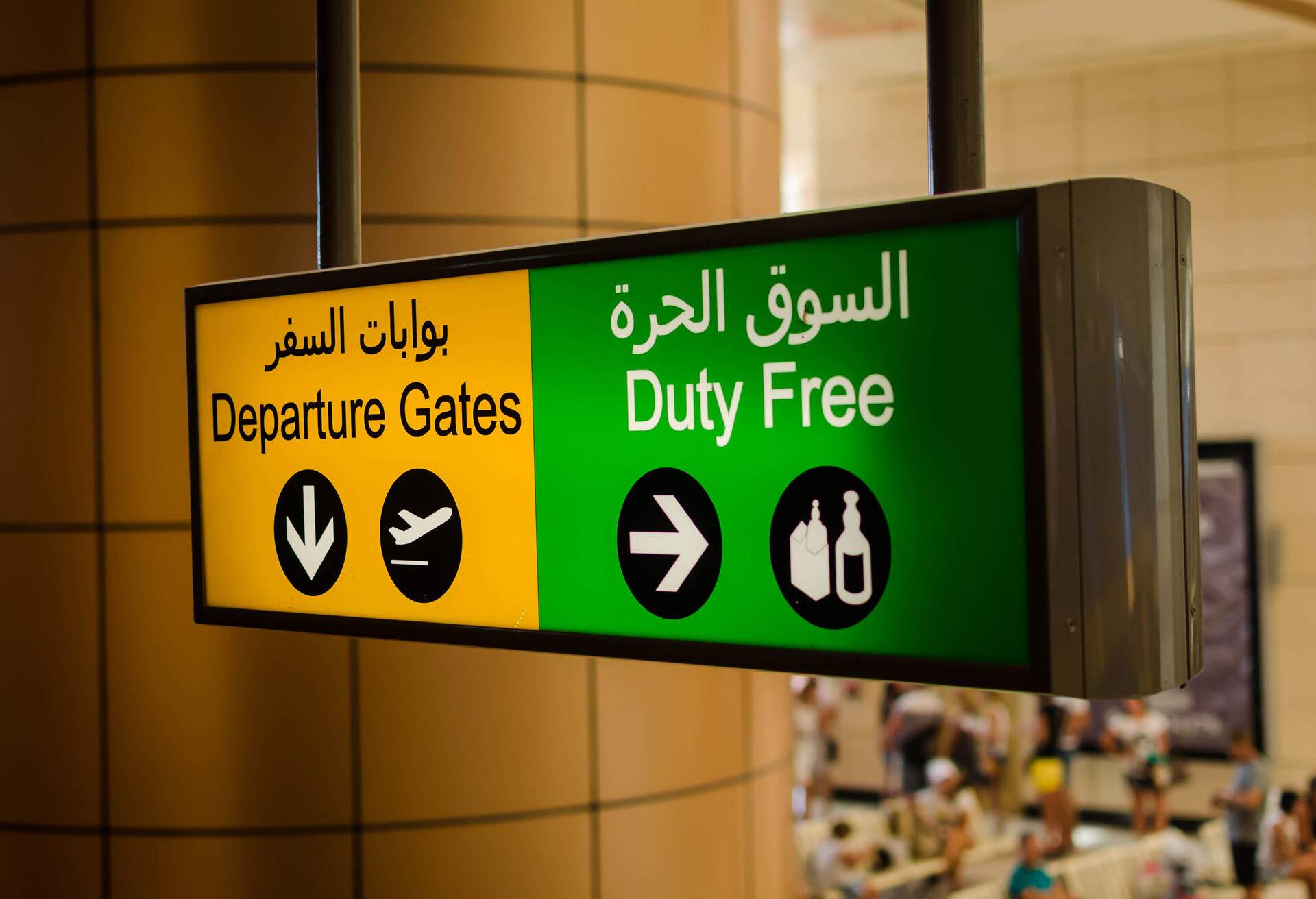 Departure gates and a Duty Free board with Arabic and English translations.
