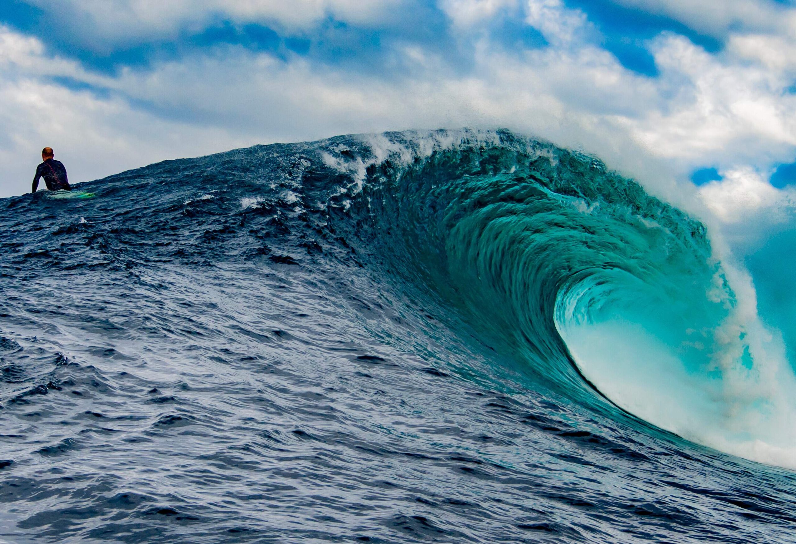 A dedicated surfer patiently waits for the perfect wave to ride amidst a massive swell.