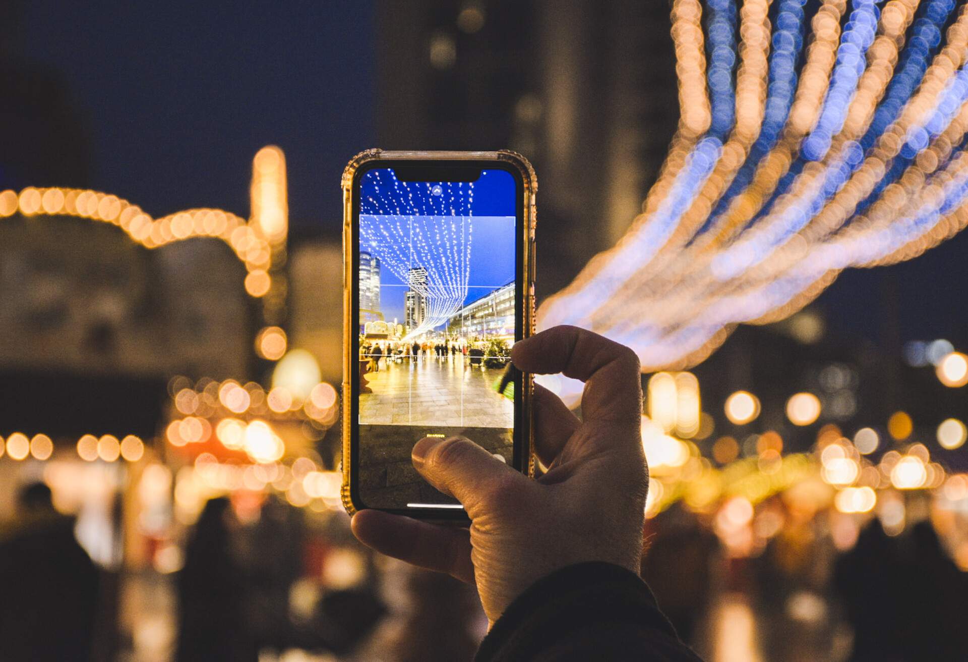 POV of man taking a photo of the Christmas lights and market in Berlin, Germany