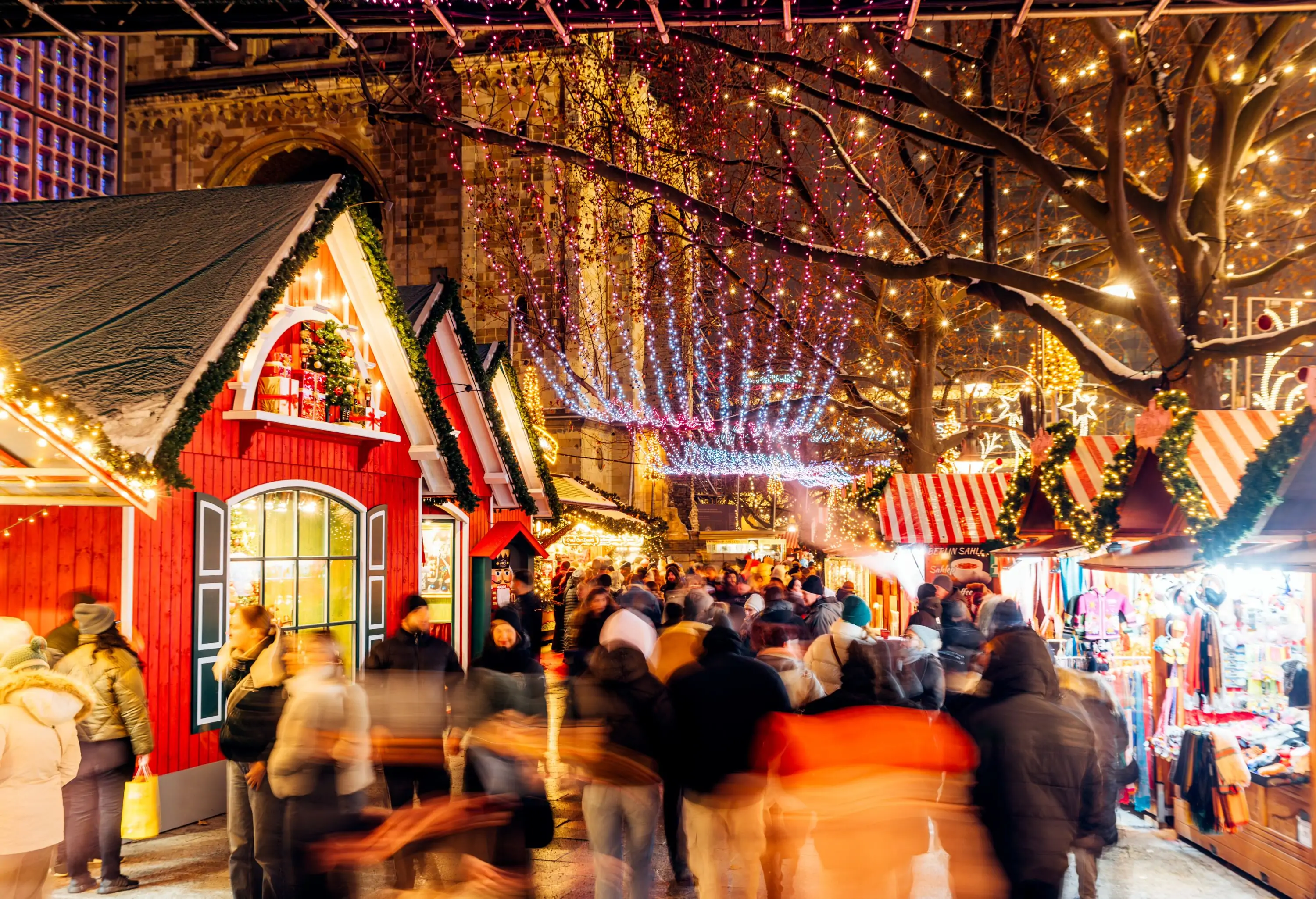 People walking among decorated market stalls at the Christmas Market, Berlin, Germany