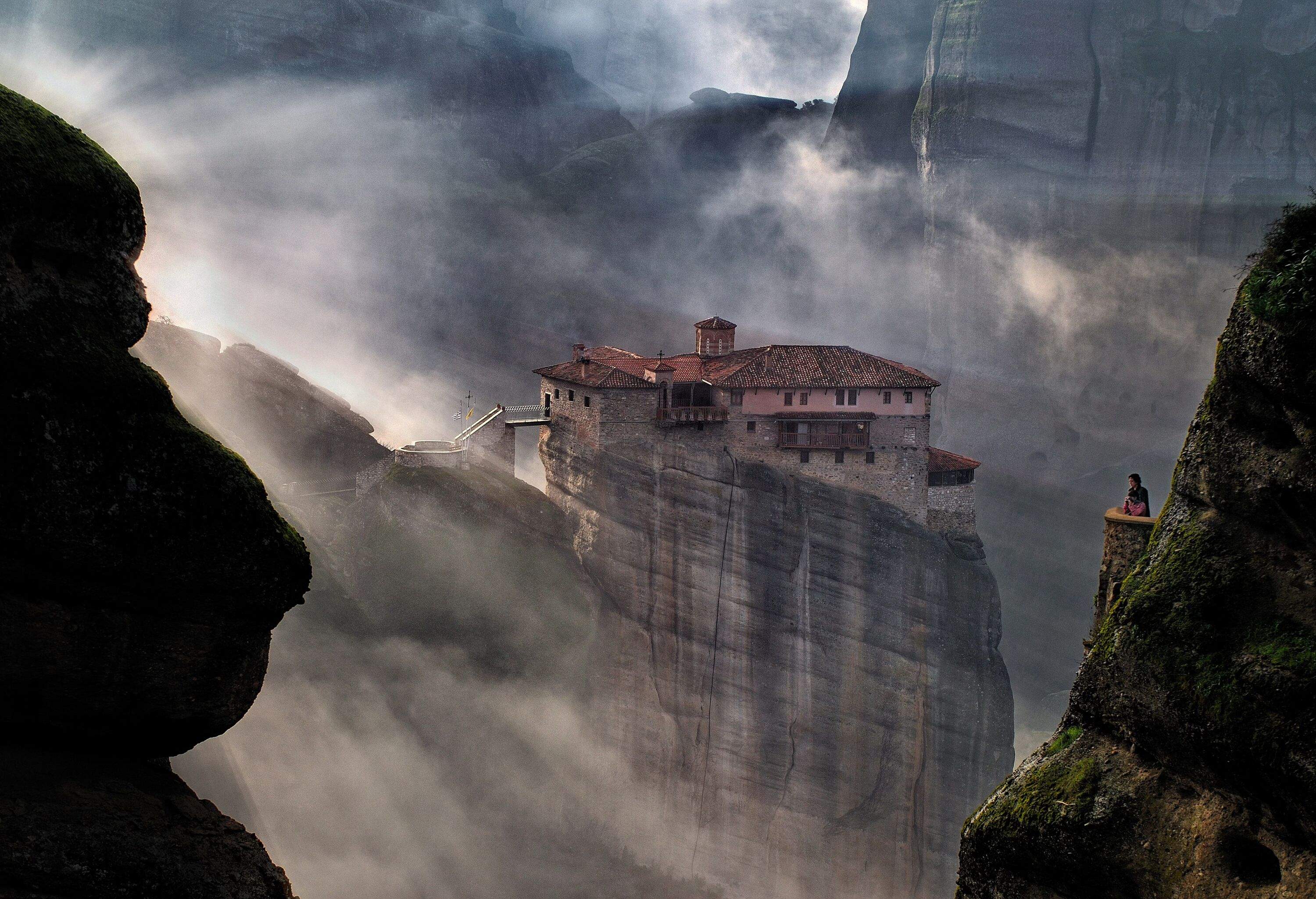 Sunbeams from sky hitting rock formations and cathedral built on top of mountain