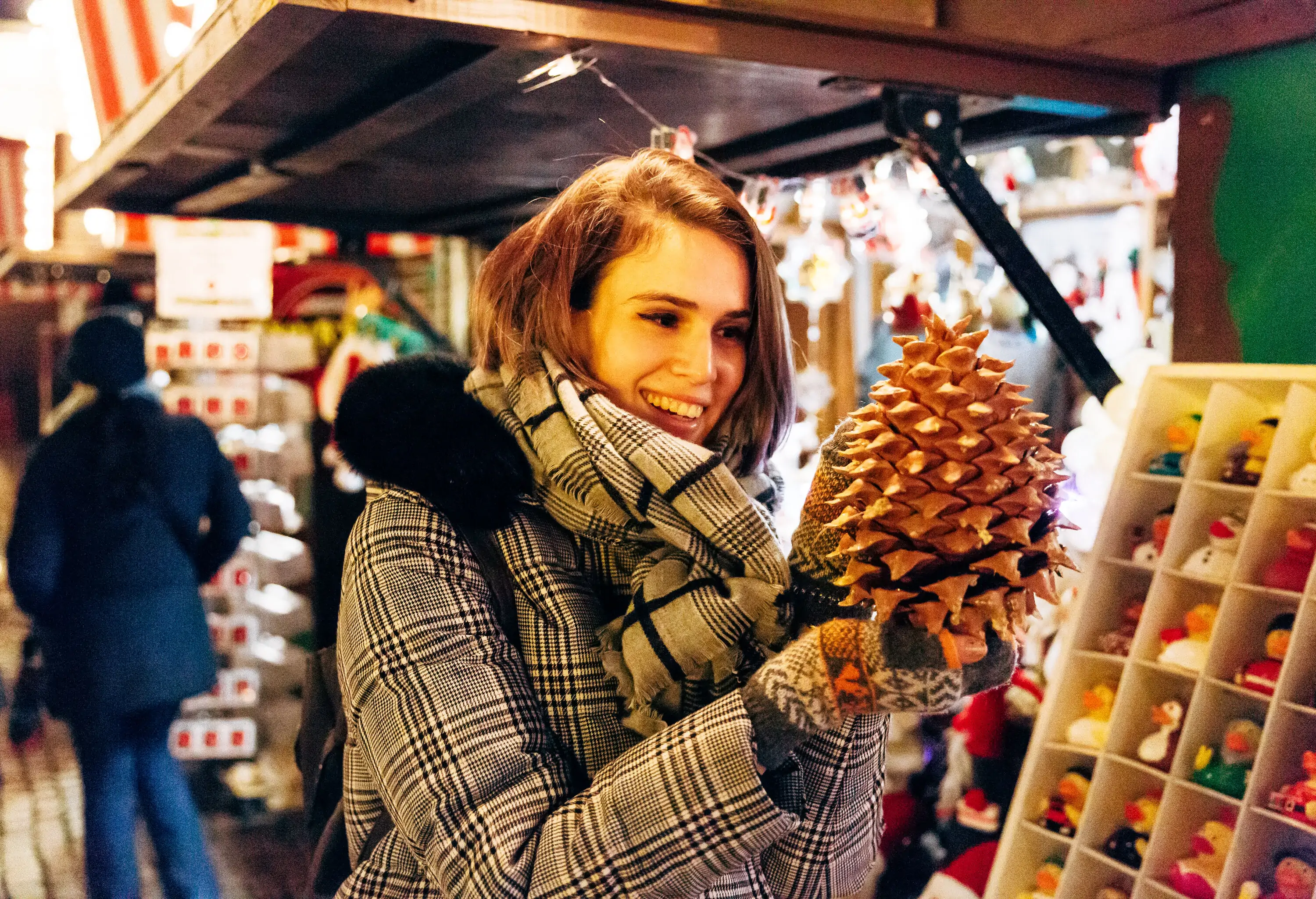 Smiling woman looking at Christmas decoration at seasonal market