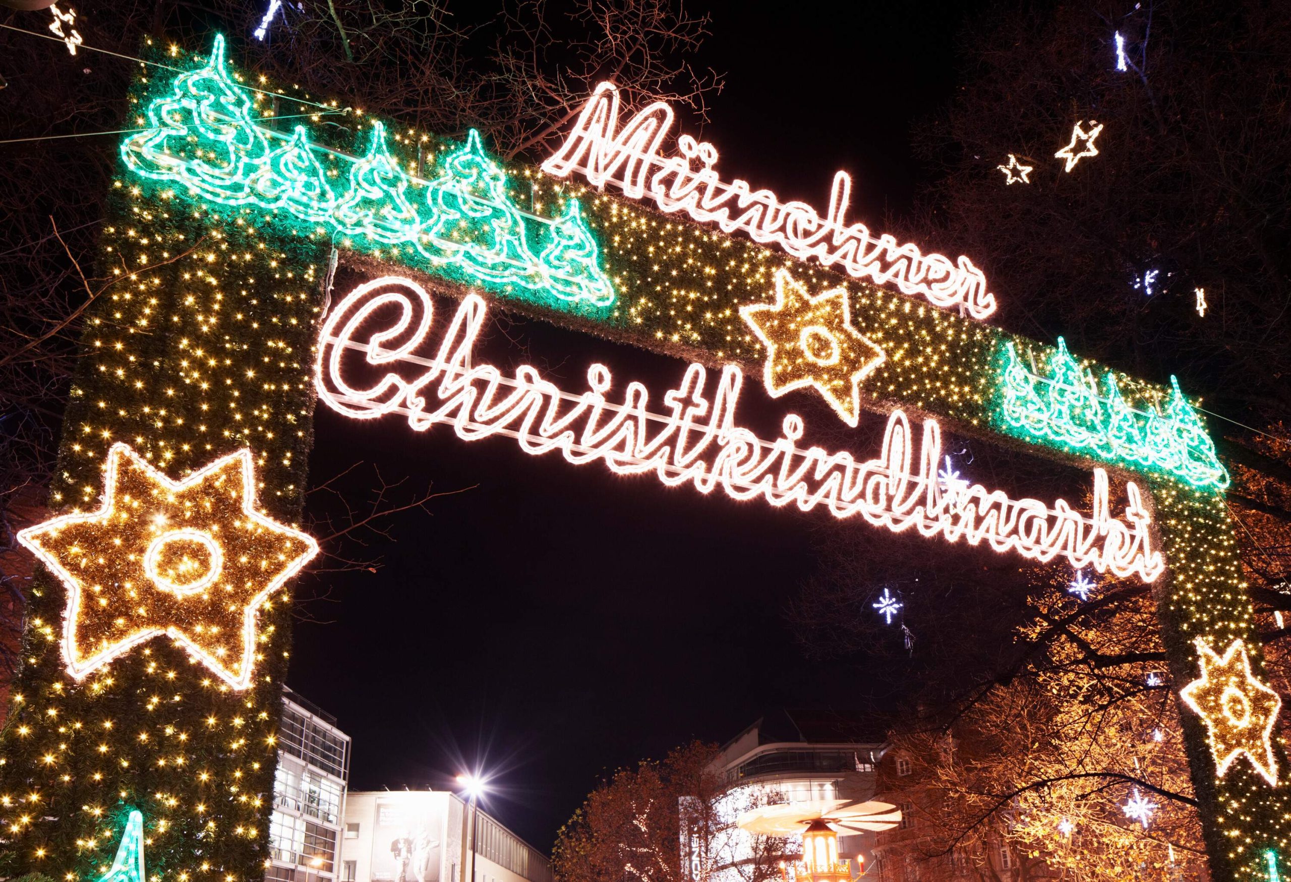 A Christmas light-adorned entrance arch that displays the market's name in the regional dialect.
