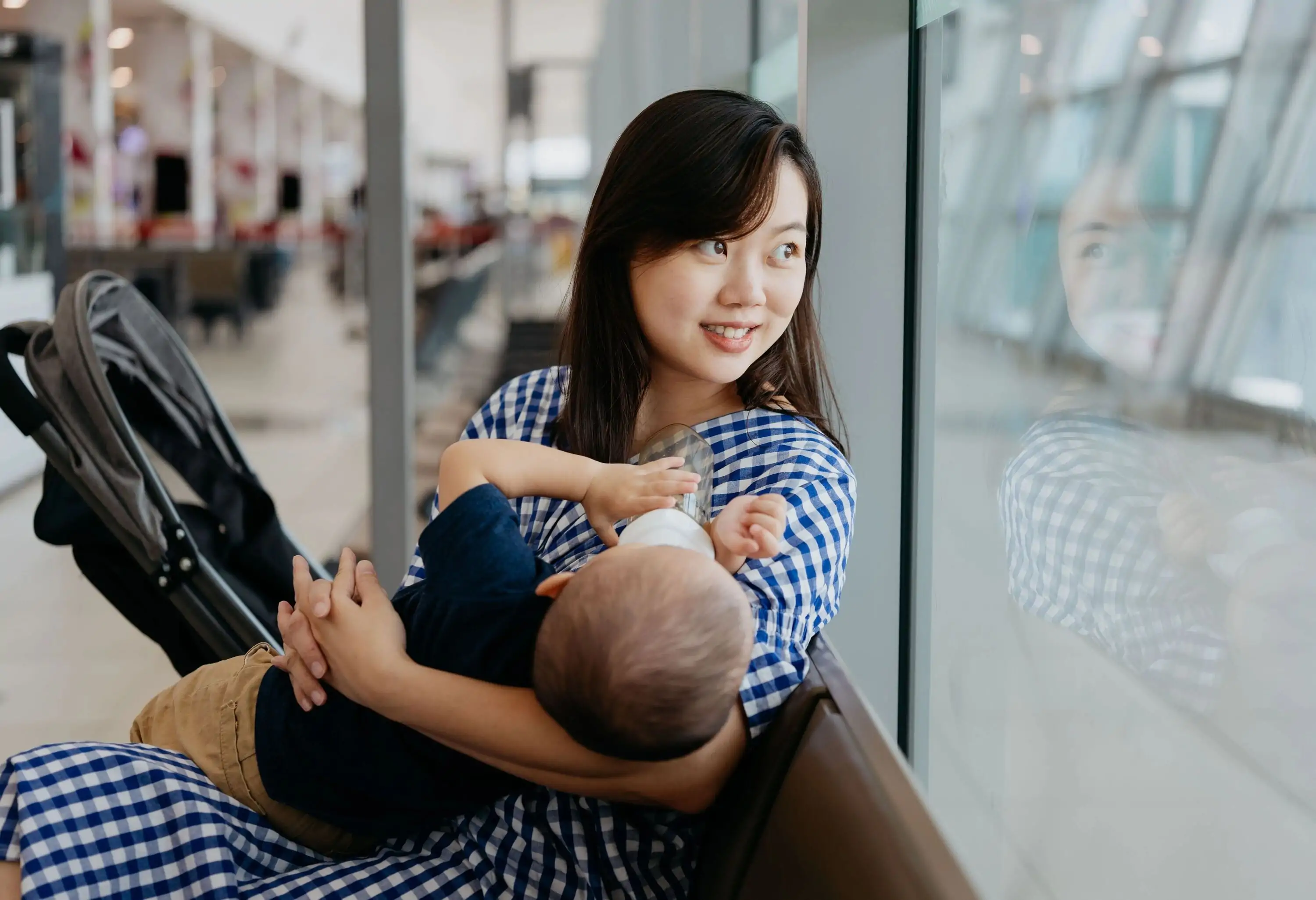 Mother holding her child and sitting at the airport