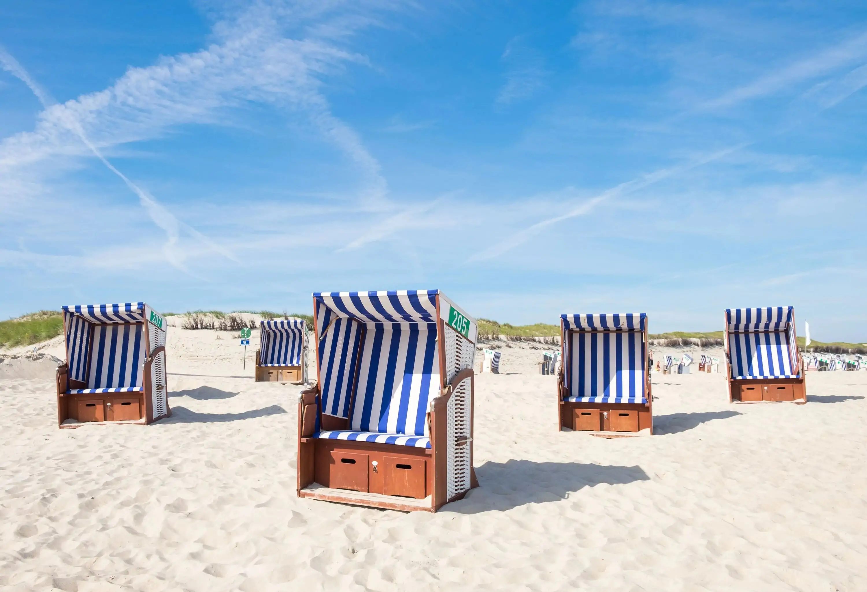 Canopy beach chairs dot the pristine shoreline.