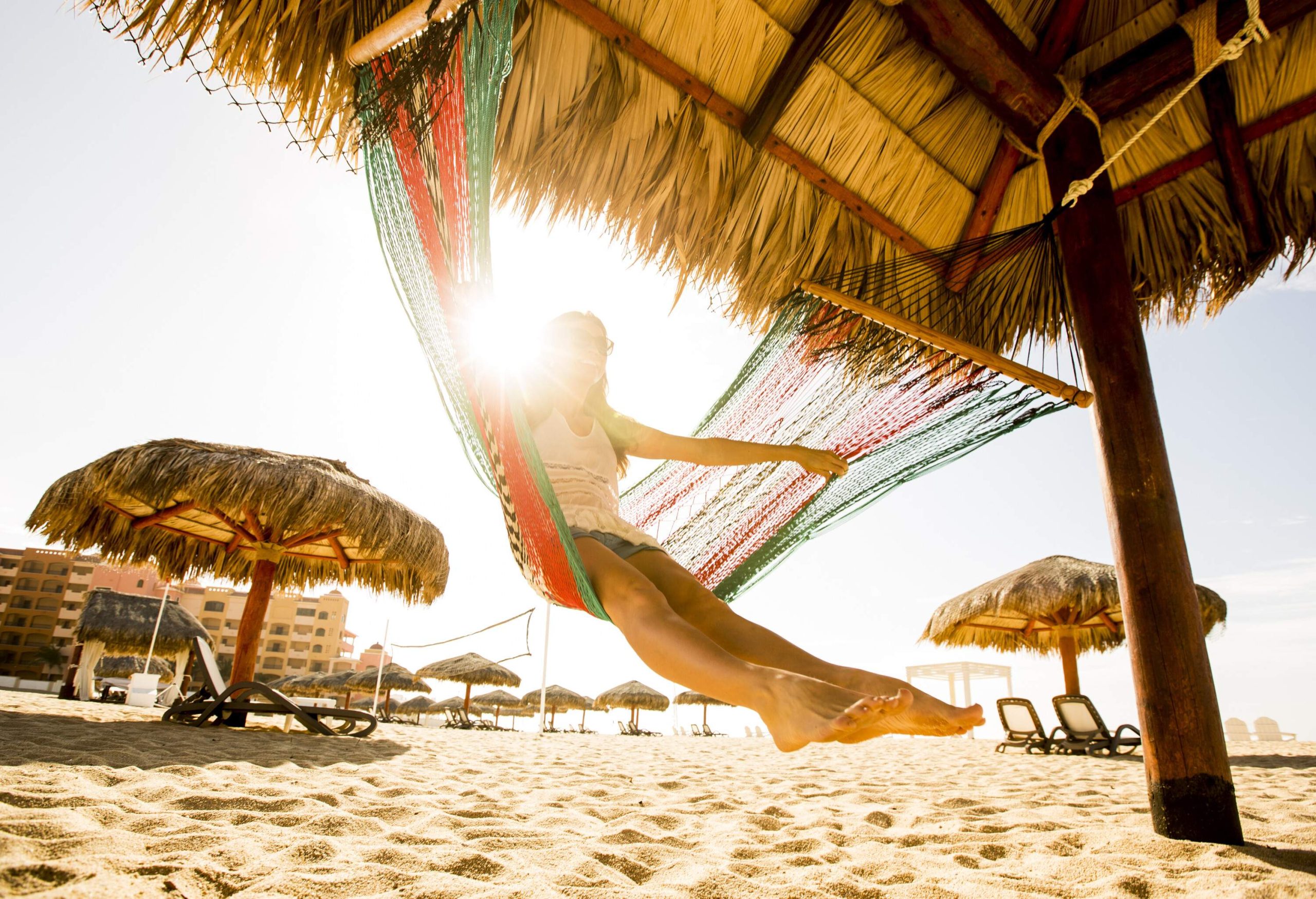 View of woman swinging on a hammock on a beach