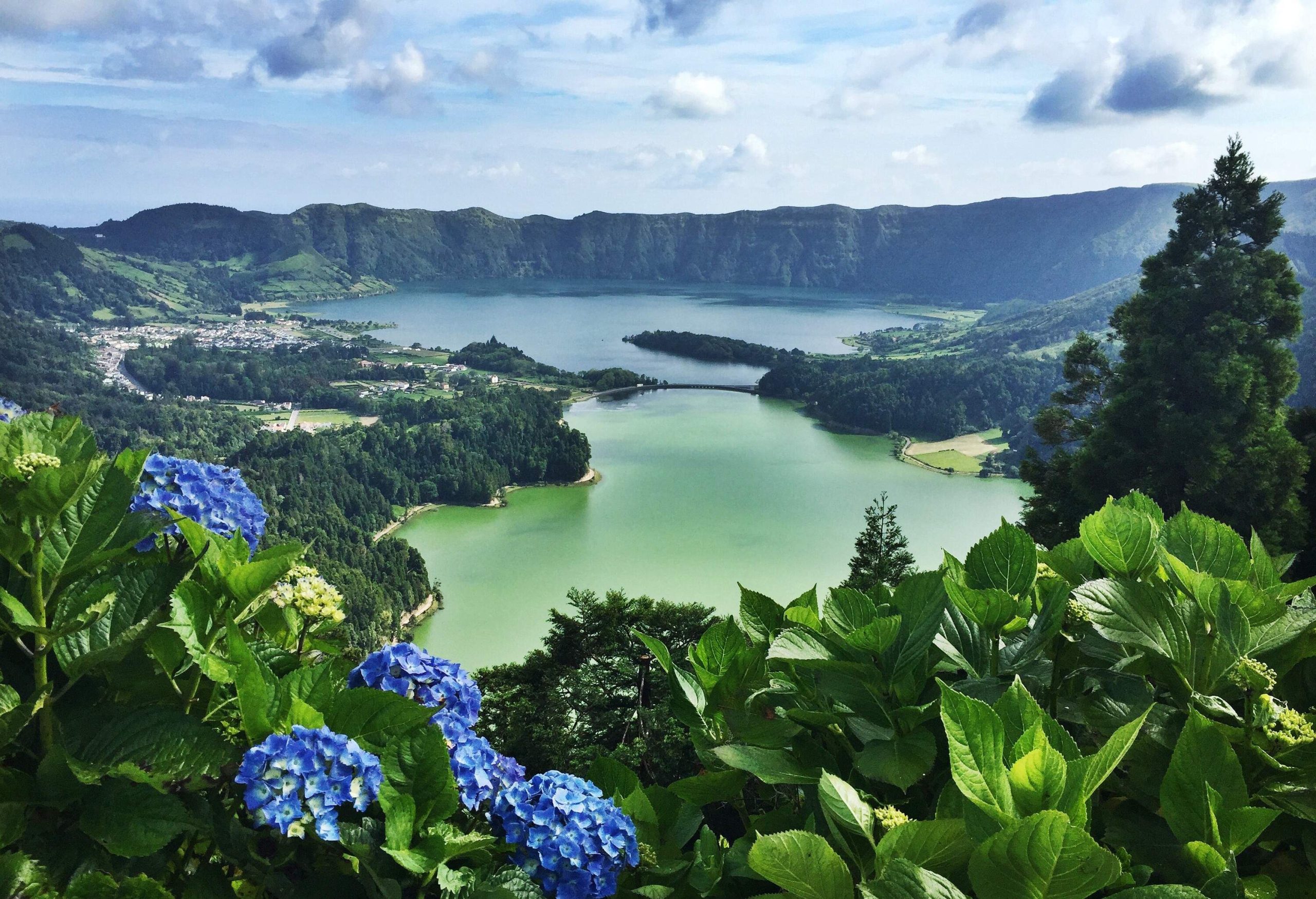 A man-made bridge separates the green and blue twin lakes in the middle of the crater.