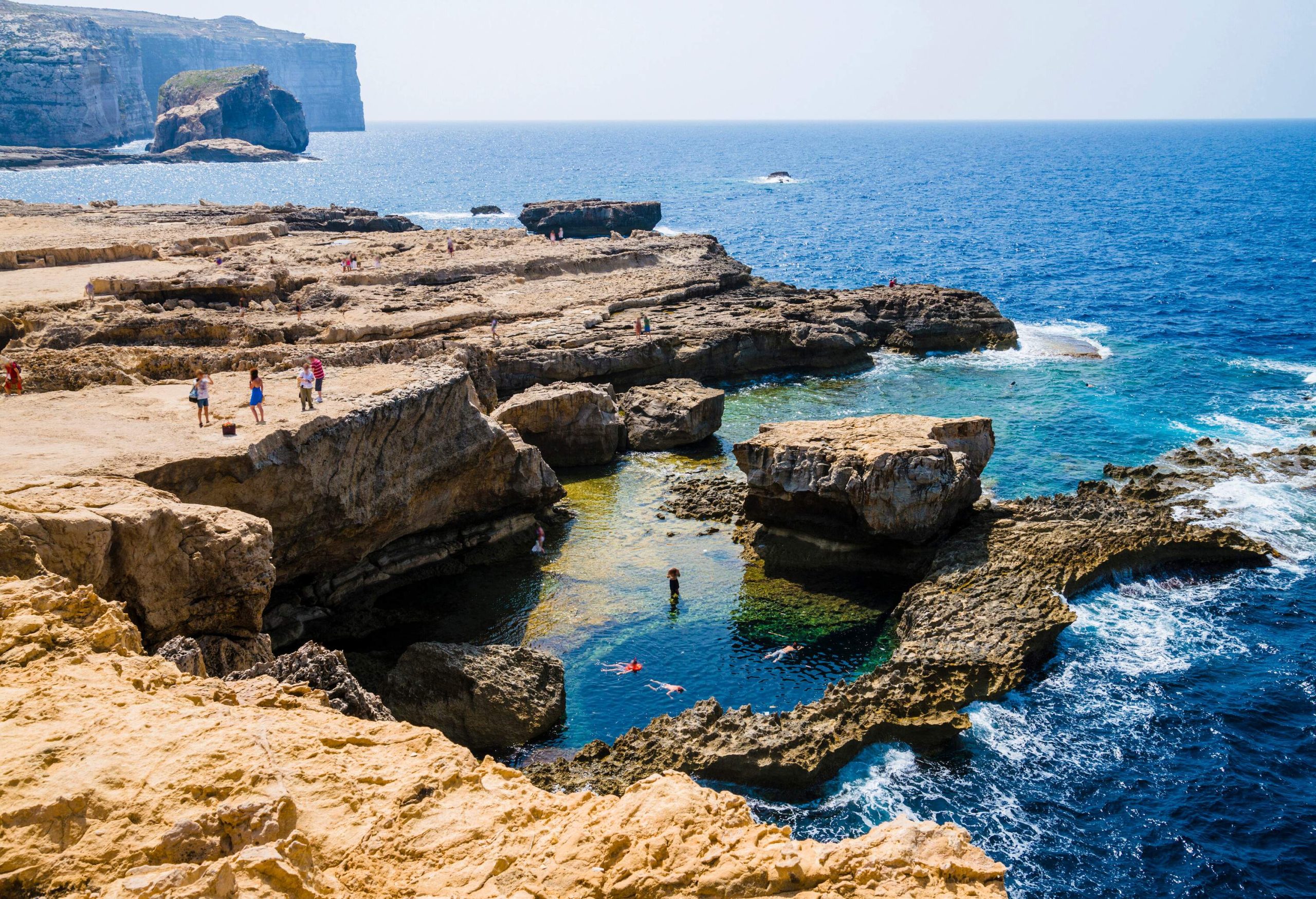 People standing on a plateau enjoying in the expansive view of the azure sea.