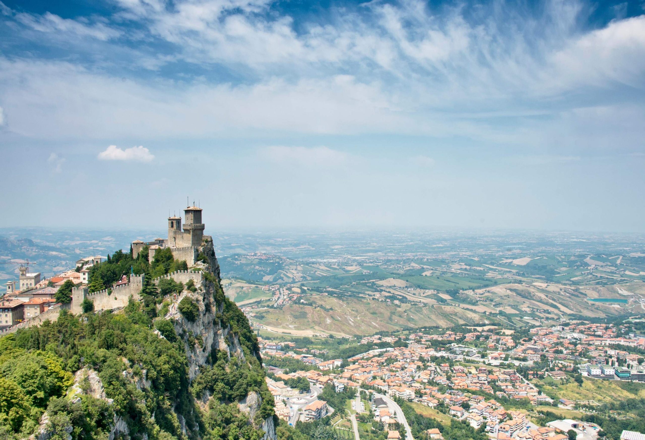 The fortress of Guaita crowned on the peak of a steep rock mountain overlooking the city on the valley.