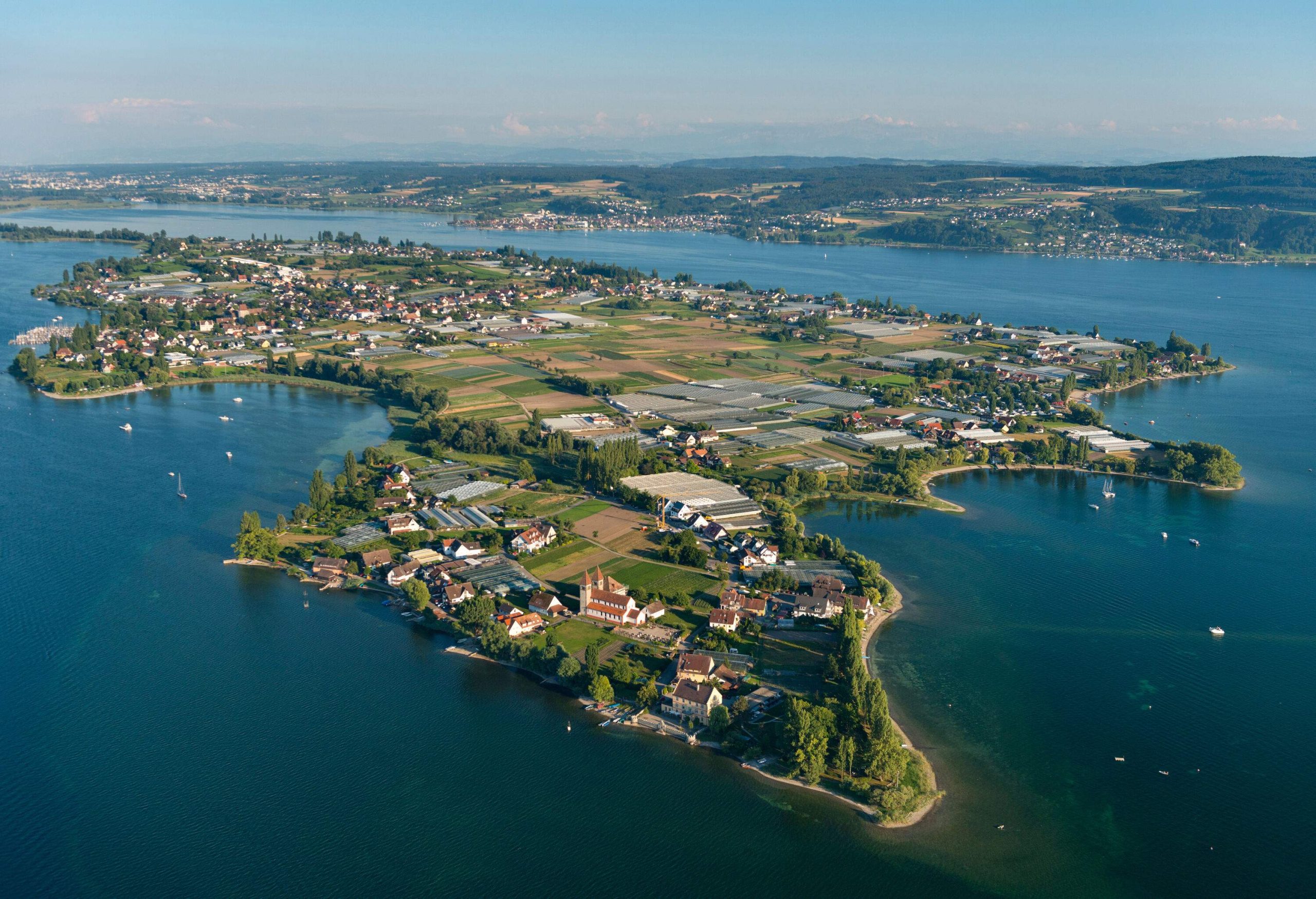 Aerial view of a colourful old town on a lush island in the lake.