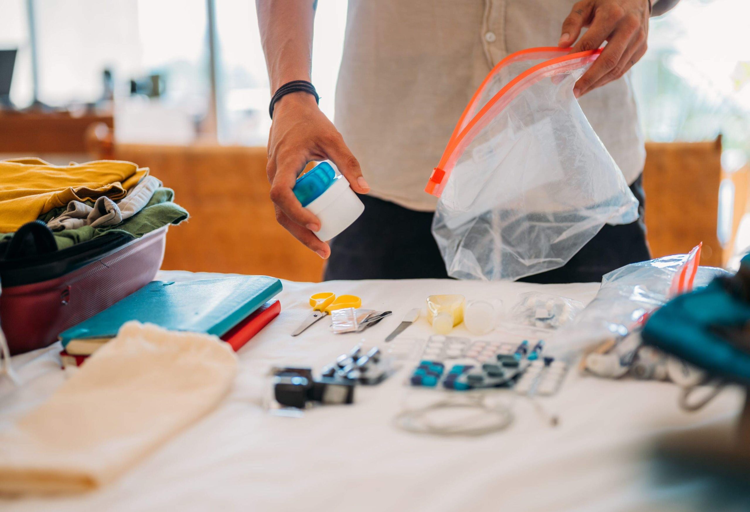 An unrecognizable man packs tablets and vitamins in transparent plastic bags with a zipper.