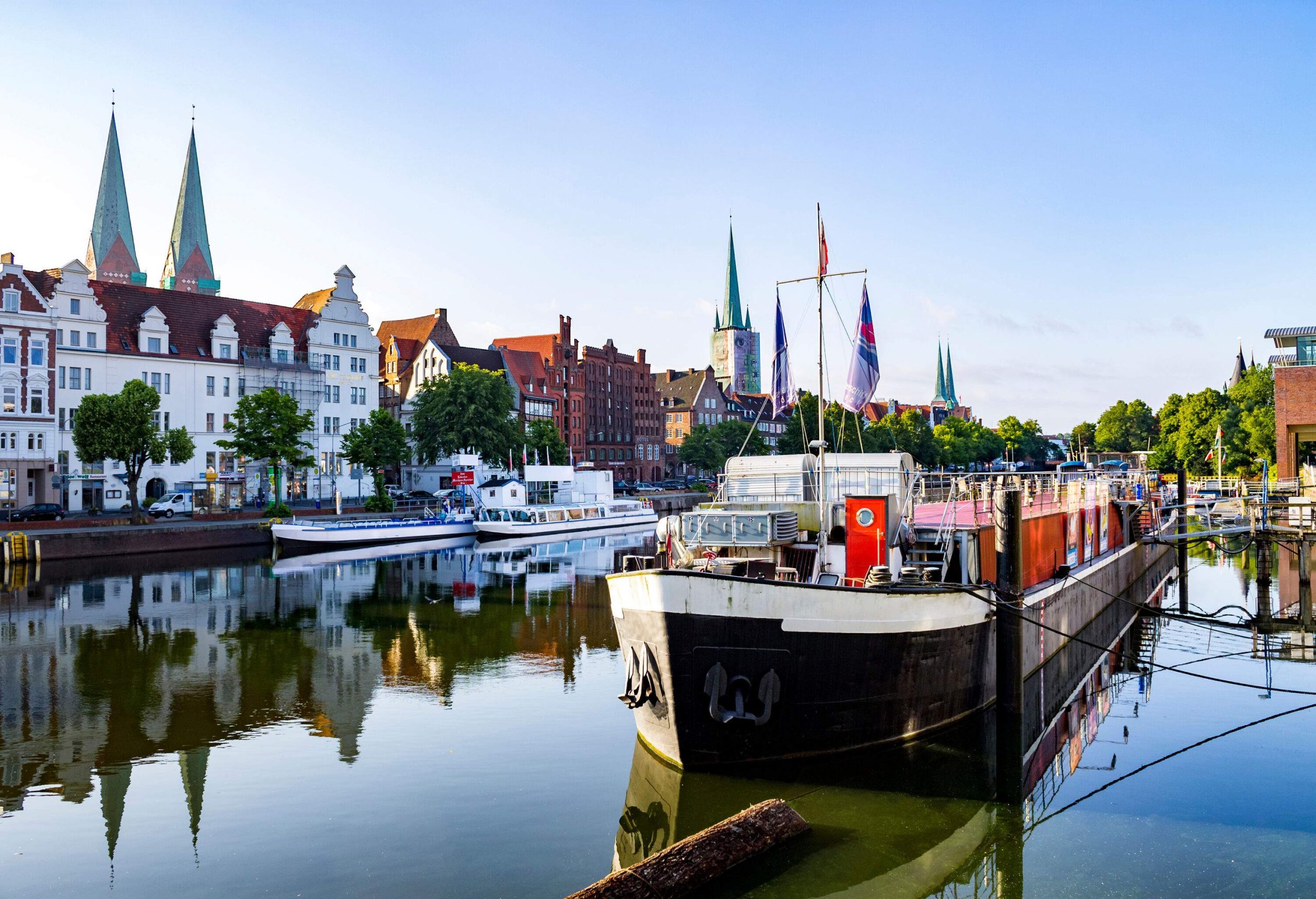 A ferry boat was stationed on the opposite bank of the river, which was lined with row houses.