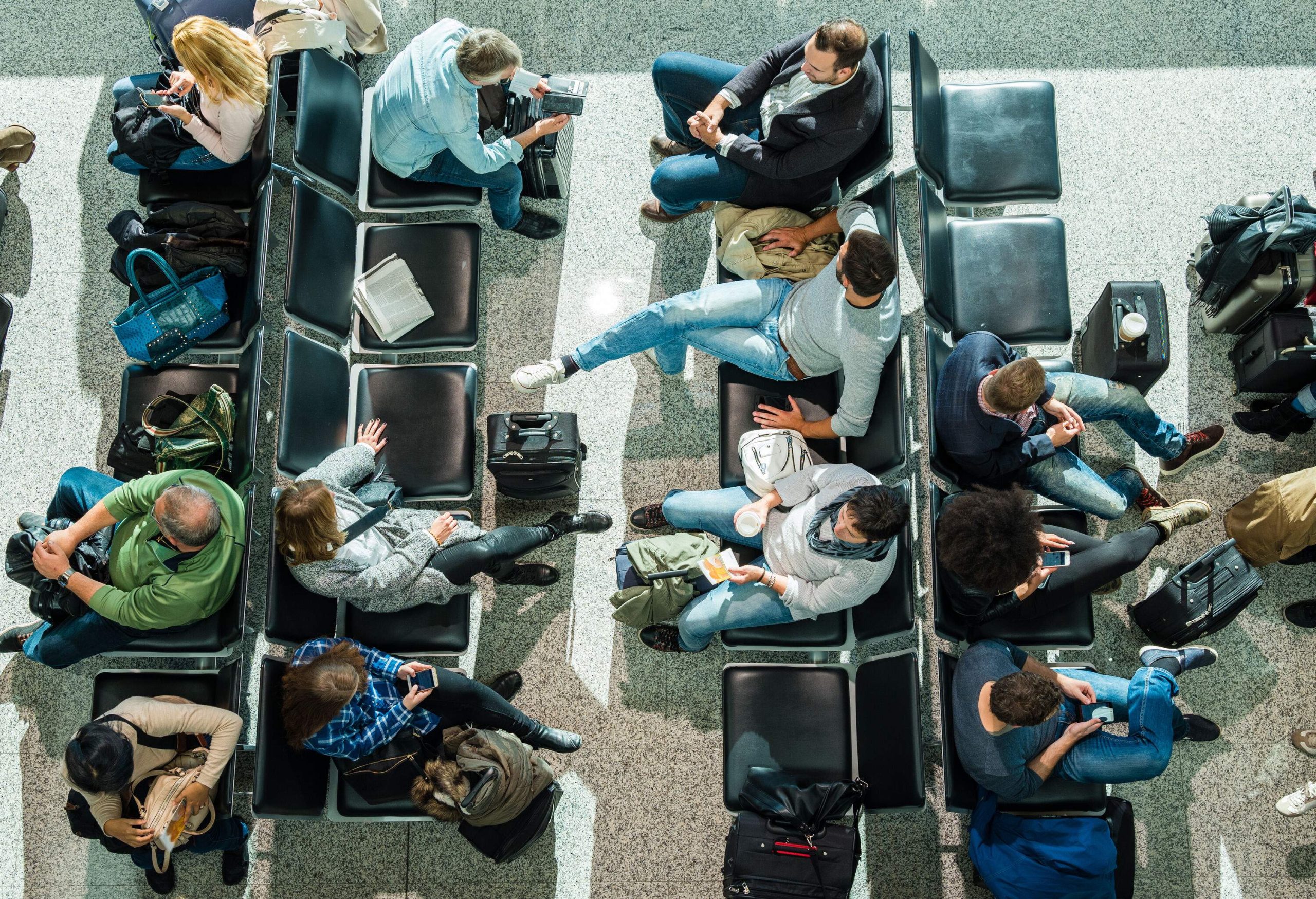 Business people waiting at airport in departure lounge.