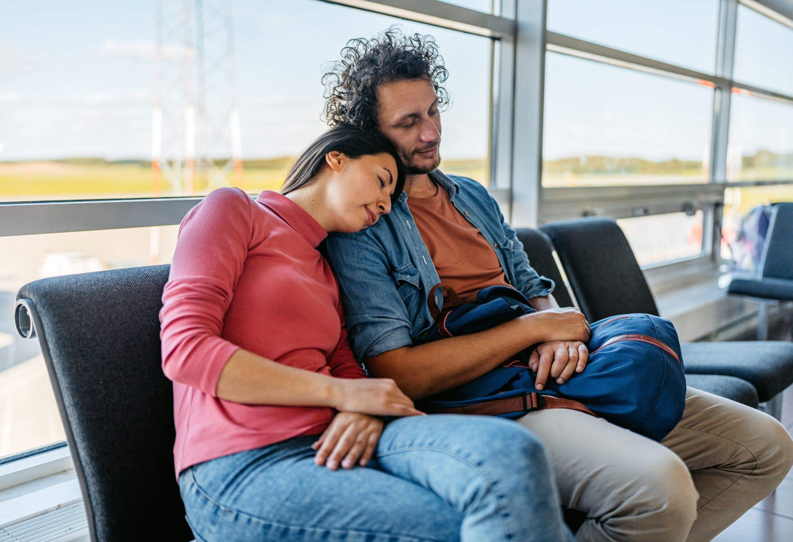 Beautiful young couple napping at the airport in Malmo, Sweden.