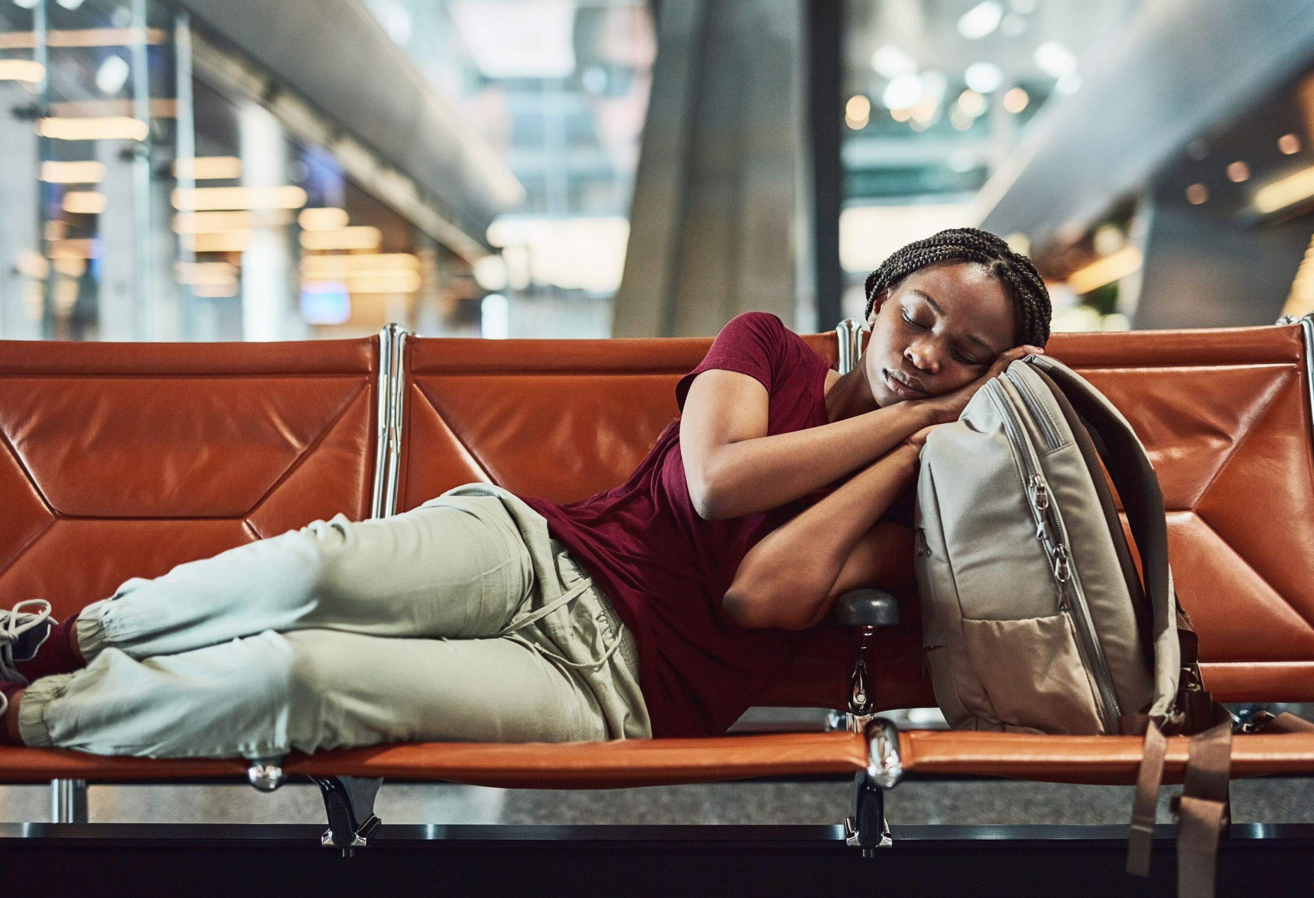 Shot of a young woman falling asleep at the airport while waiting for departure