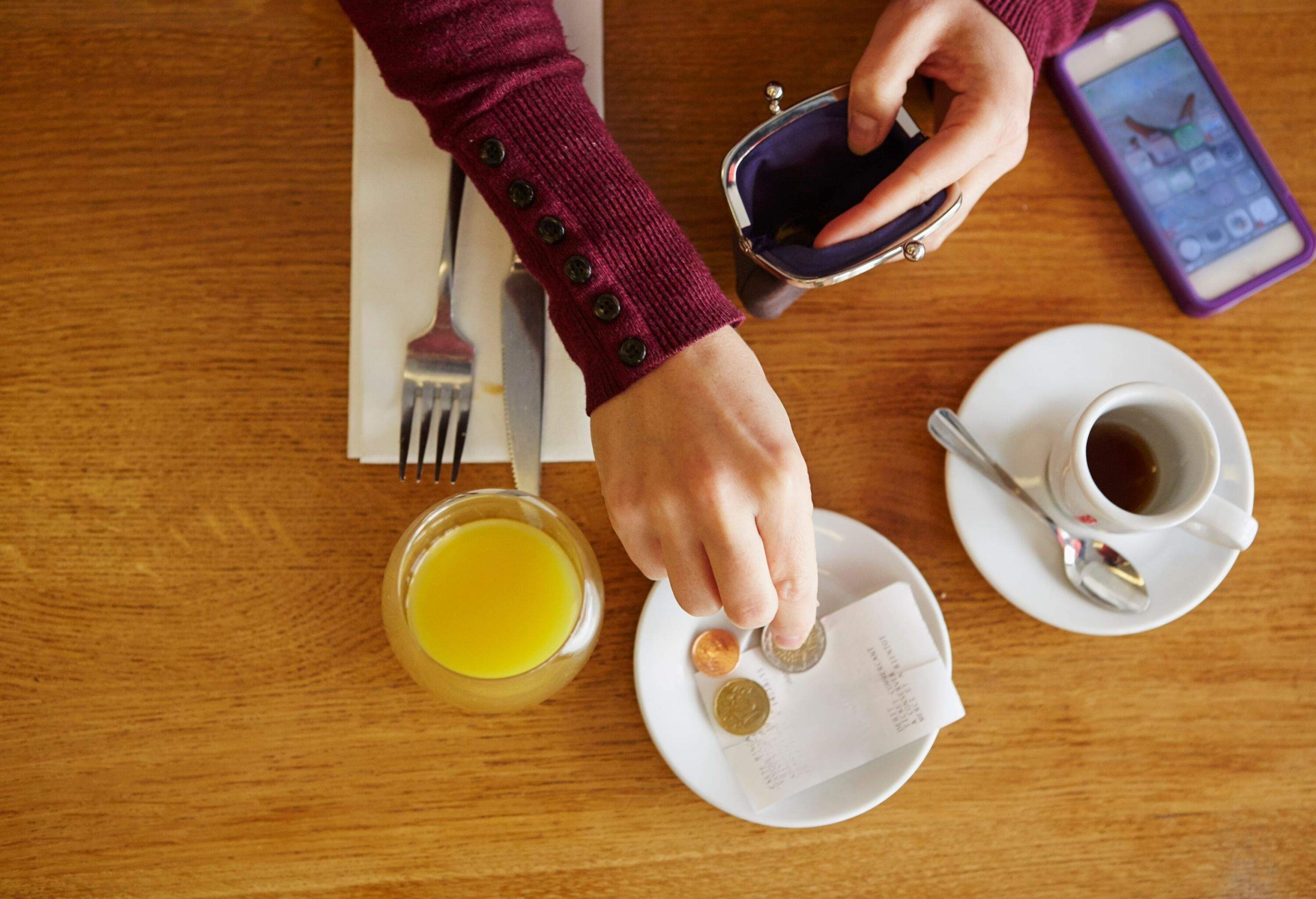 Close up of woman's hand leaving tip in cash in a restaurant