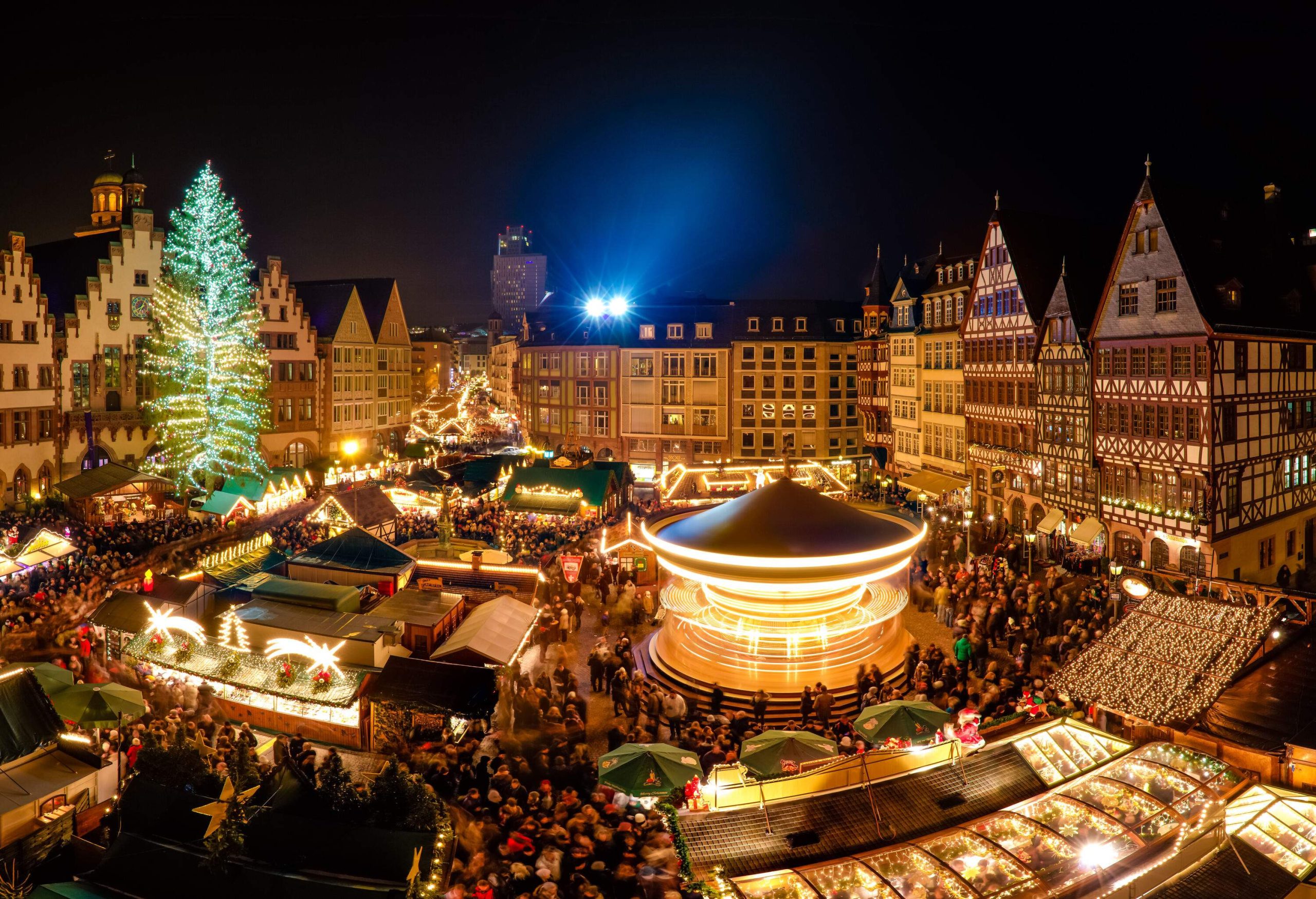 A festive market filled with attractions and shops shimmering in decorative lights.