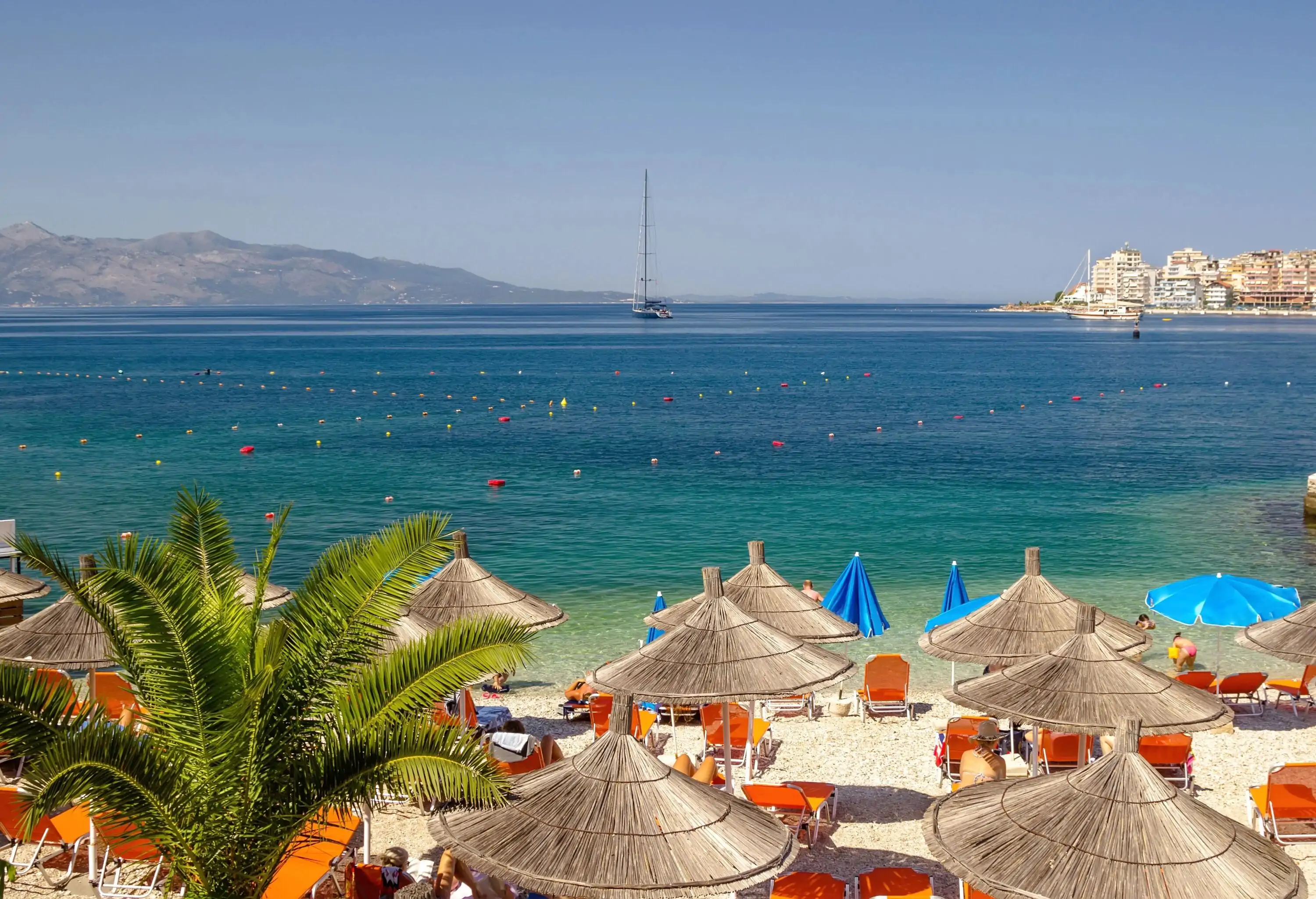 Serene blue water beach with umbrellas for a holiday in the Ionian Sea