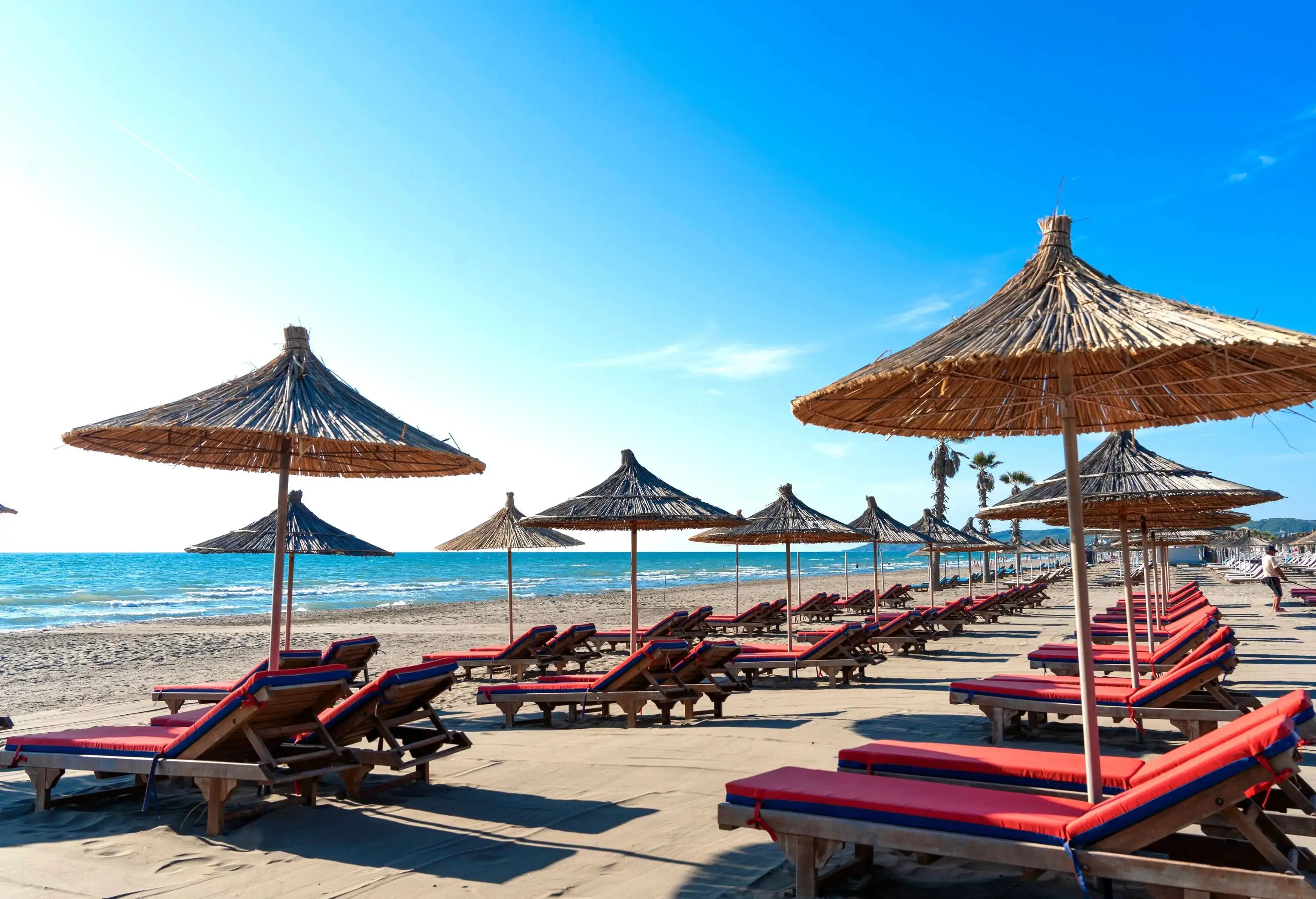 Beach umbrellas and red sun beds on beach